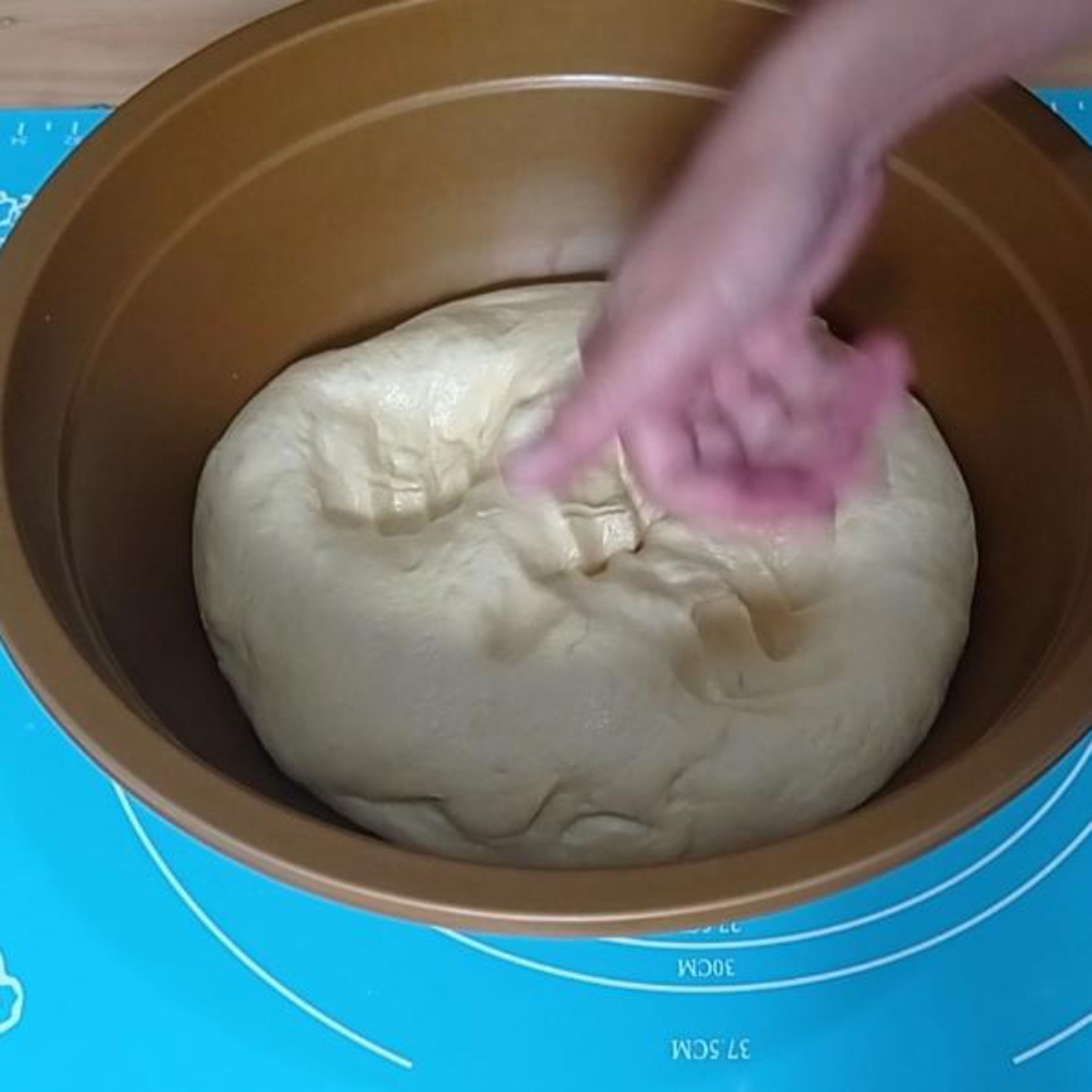 After 1 hour, open the kitchen towel and punch the dough to remove the air bubbles. Make the dough into a ball and divide the dough into 9 pieces.