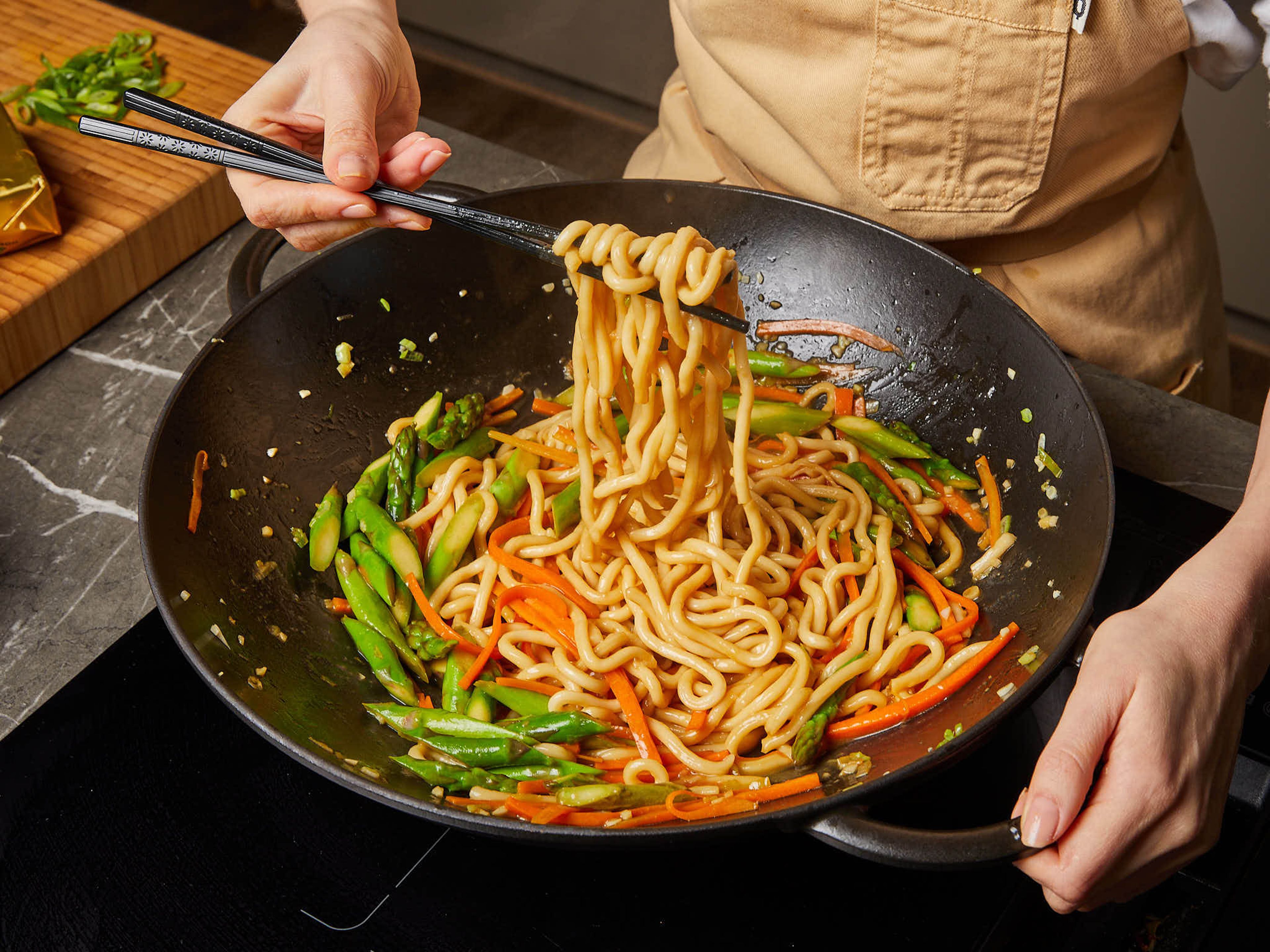 Add the loosened udon noodles and stir-fry for approx. 3 min. Add butter, lemon juice, agave nectar, and soy sauce and mix everything well until it’s all coated with the sauce. Garnish with sesame seeds and green part of the scallion. Serve immediately.
