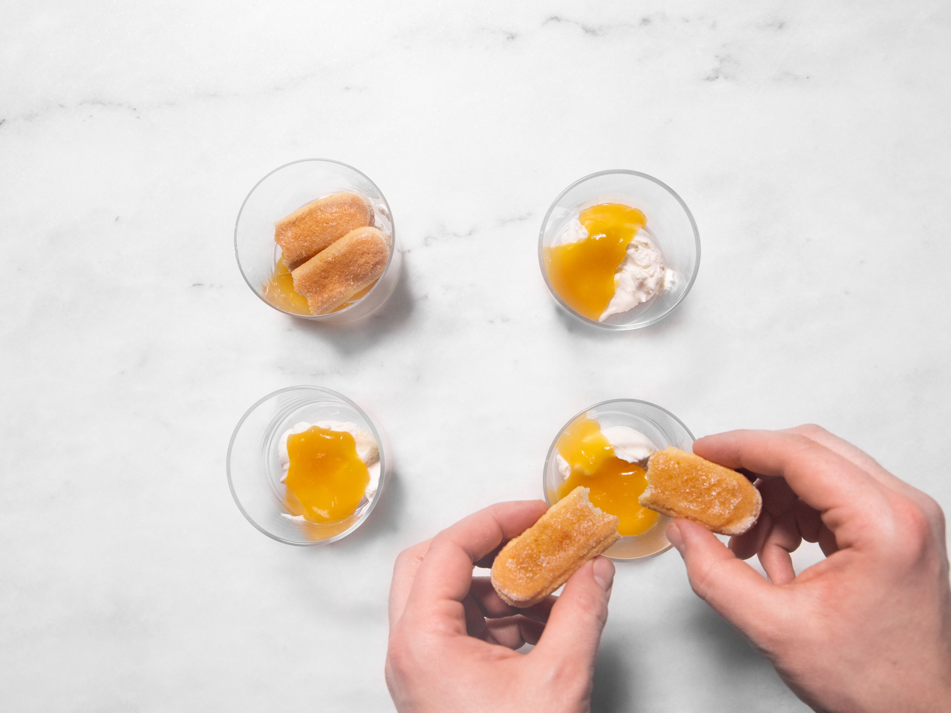 Layer the dessert in individual glasses in this order: cream mixture, lemon curd, dipped lady finger, lemon curd, cream mixture. Top with toasted cashews and remaining lemon zest. Enjoy!