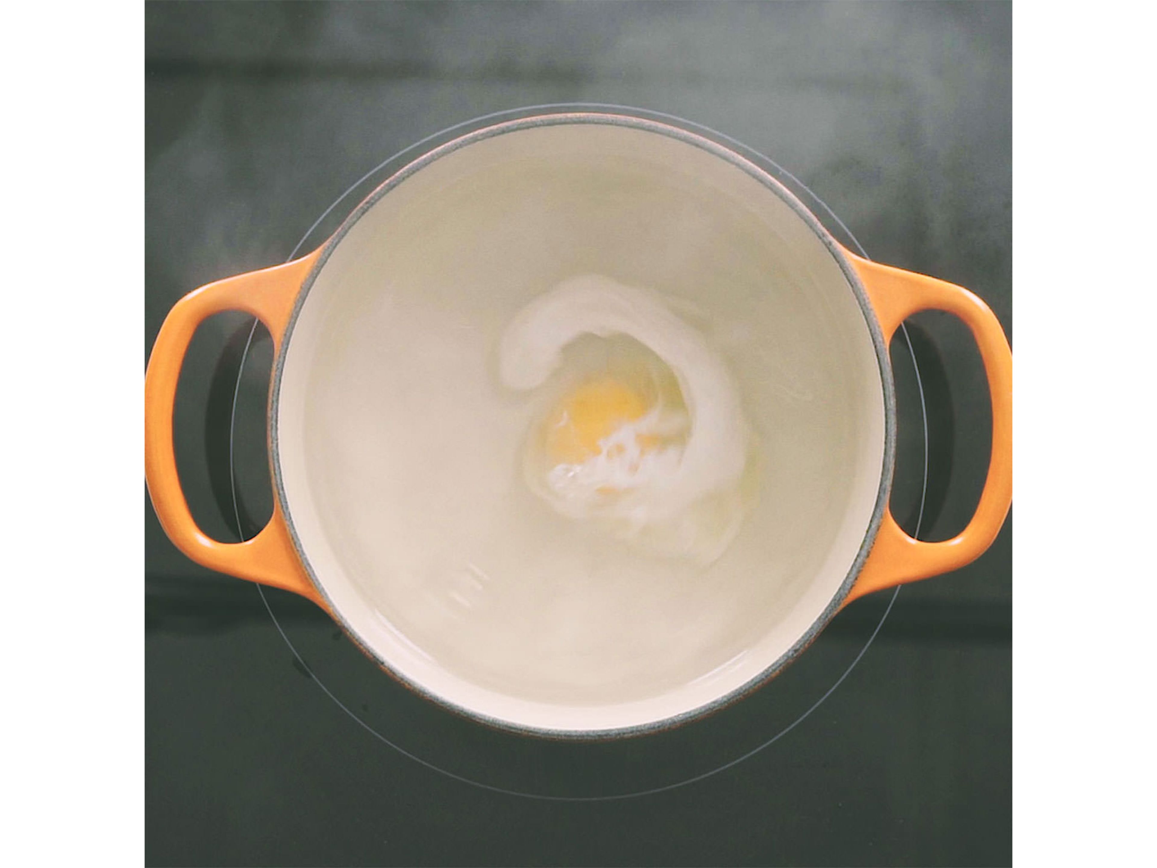 Bring a medium pot of water to a simmer. Add salt and white vinegar. Use wooden spoon to create a whirlpool, then slowly add egg. Let cook until egg white is set, approx. 3 min.