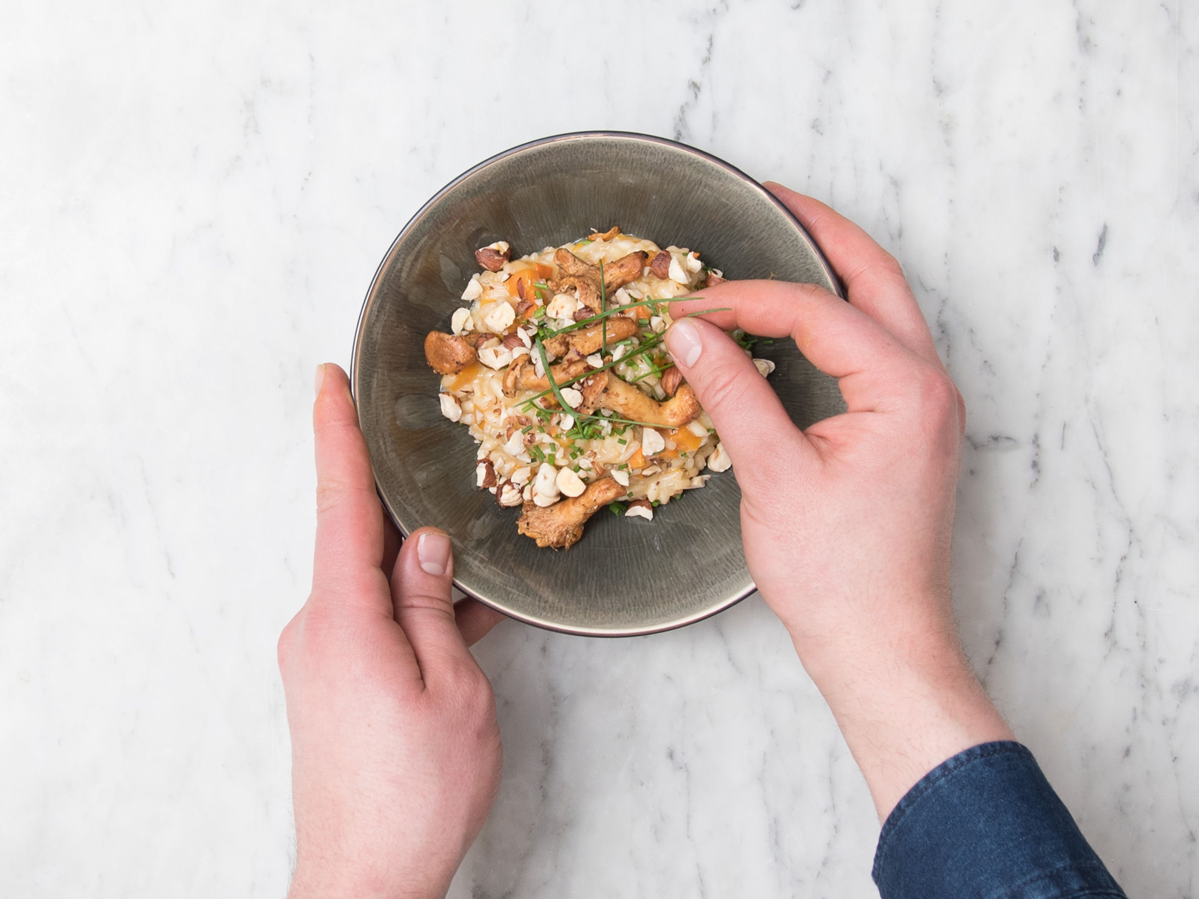 Das Kürbis-Risotto auf Teller oder Schüsseln verteilen, mit Pfifferlingen garnieren und mit Haselnüssen, Schnittlauch und Parmesan bestreuen. Mit Salz und Pfeffer abschmecken. Guten Appetit!