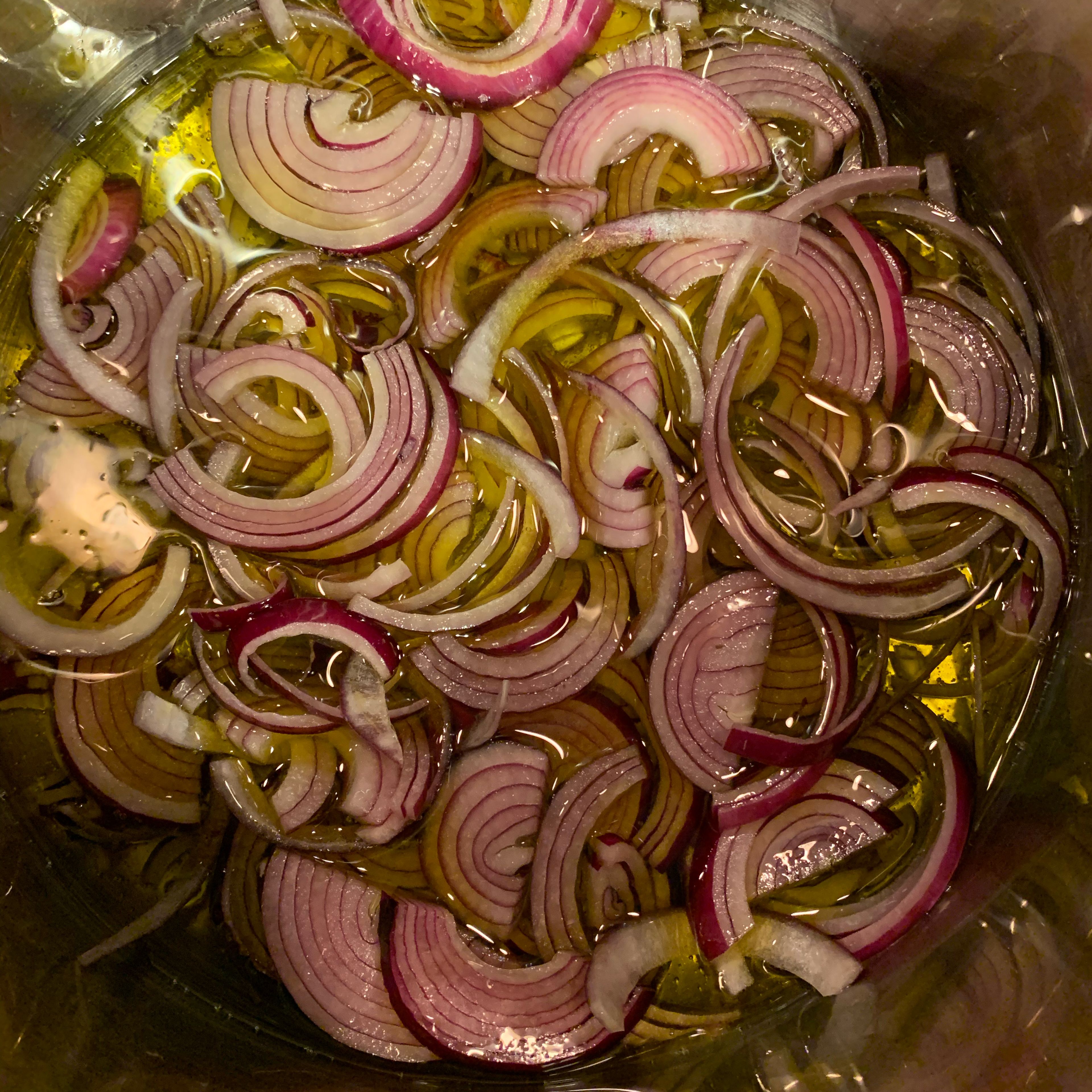 Use a generous amount of extra virgin olive oil, about 1 inch from the bottom of the pot. Set on medium heat. Throw in sliced onions, raise heat to medium high, cover pan and get the onions going. Once they are boiling in the oil lower the heat to medium low.