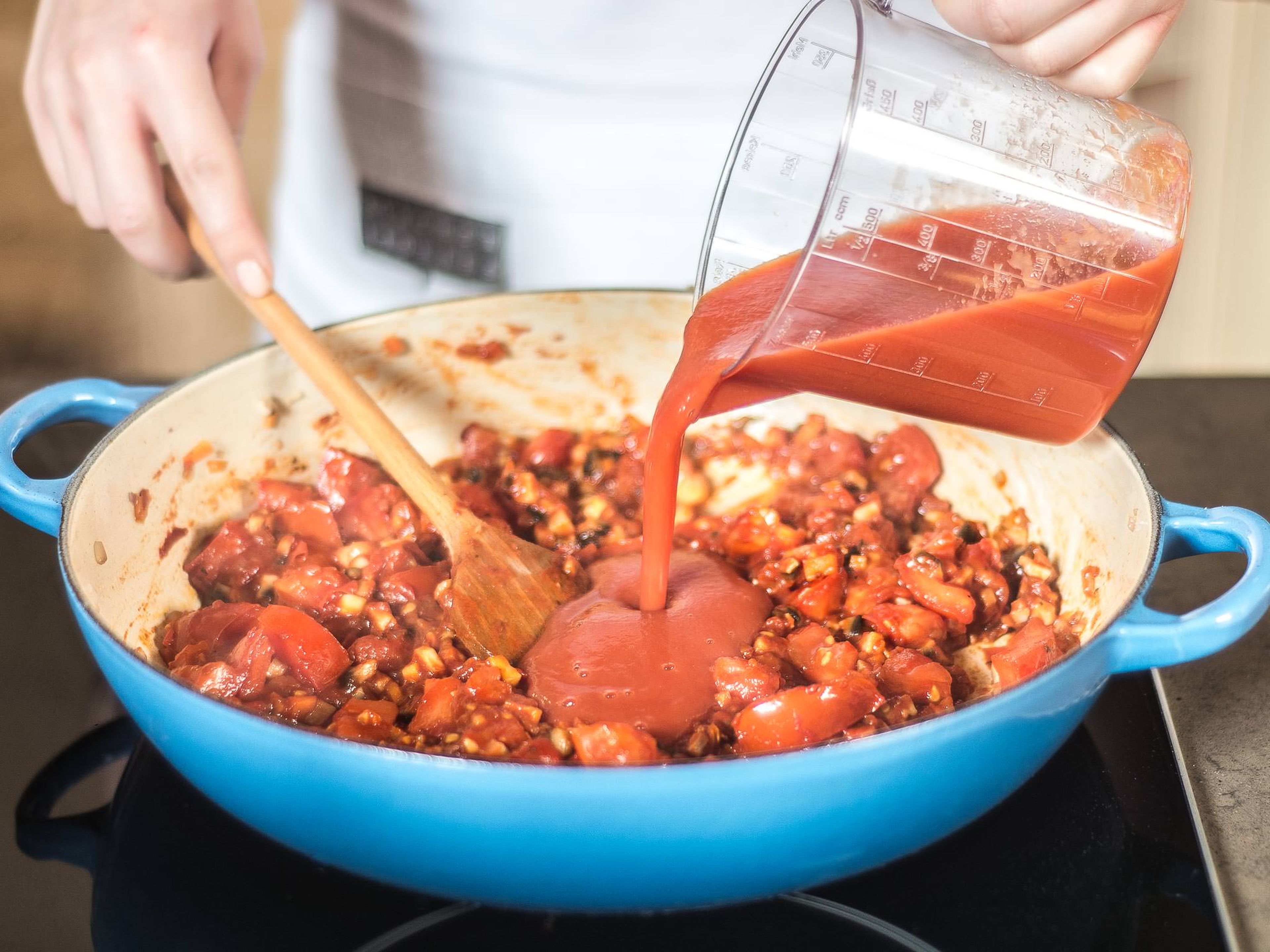 Tomatenmark hinzugeben und mit anrösten. Mit passierten Tomaten aufgießen und alles ca. 10 Min. bei niedriger Hitze einkochen lassen.