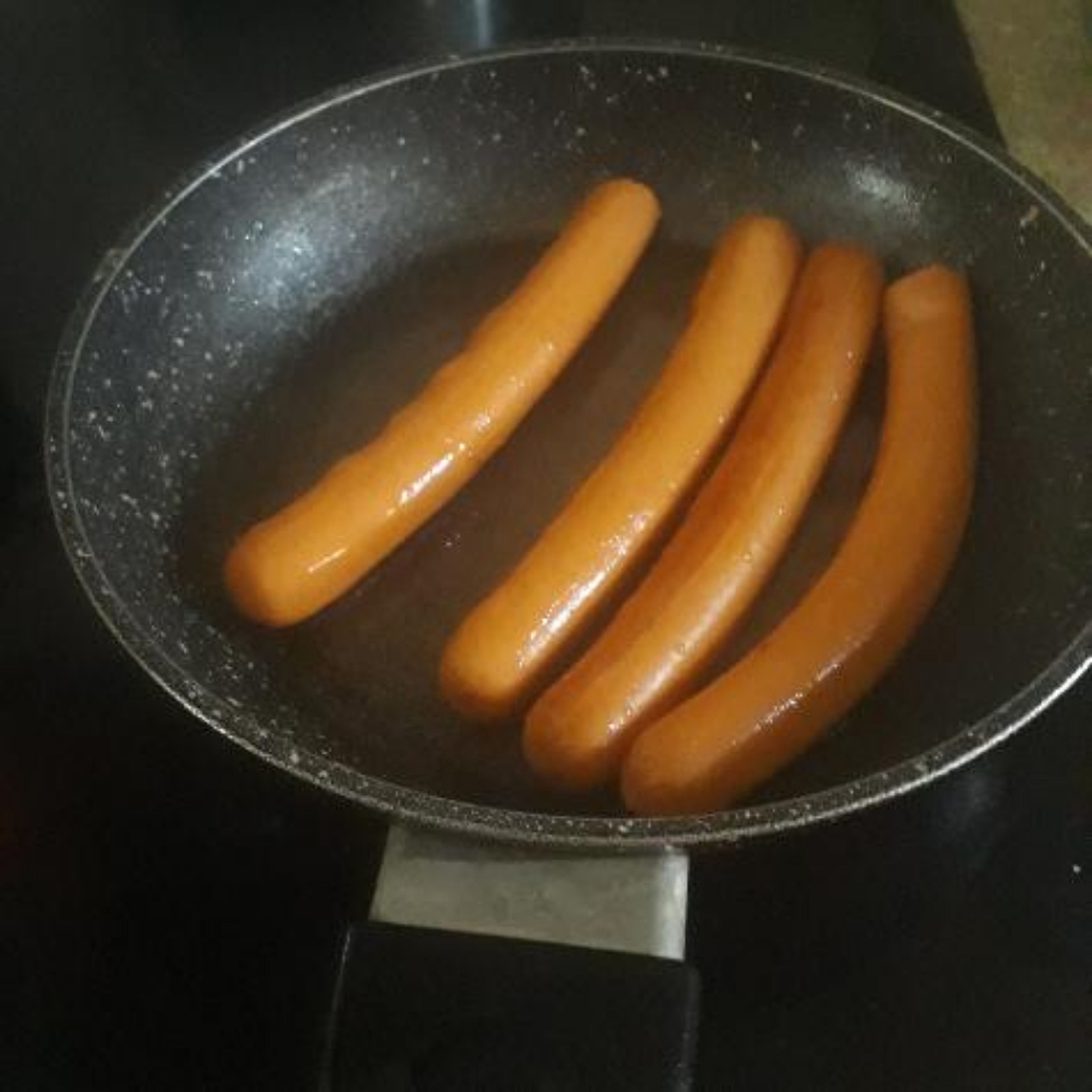 put 3 or 4 sausages in and turn the volume lower. wait till the sausages have a darker colour and heat coming, then turn them around and wait 4 min. once you have waited get a fork and place them on a plate