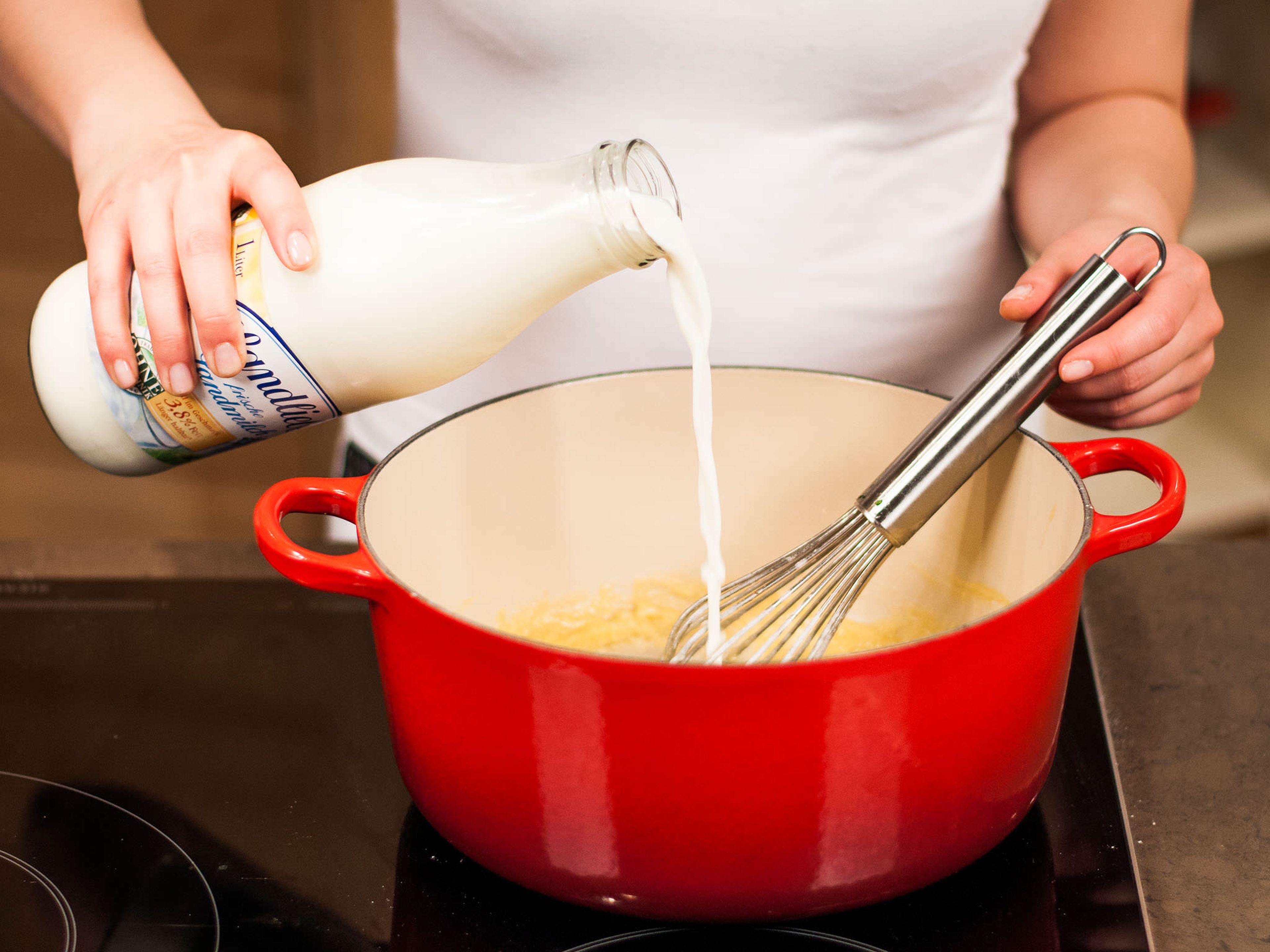 Nach und nach und unter ständigem Rühren kalte Milch hinzugeben und die Hitze reduzieren, für etwa 5-8 Min. Mit Muskat, Salz und Pfeffer abschmecken.