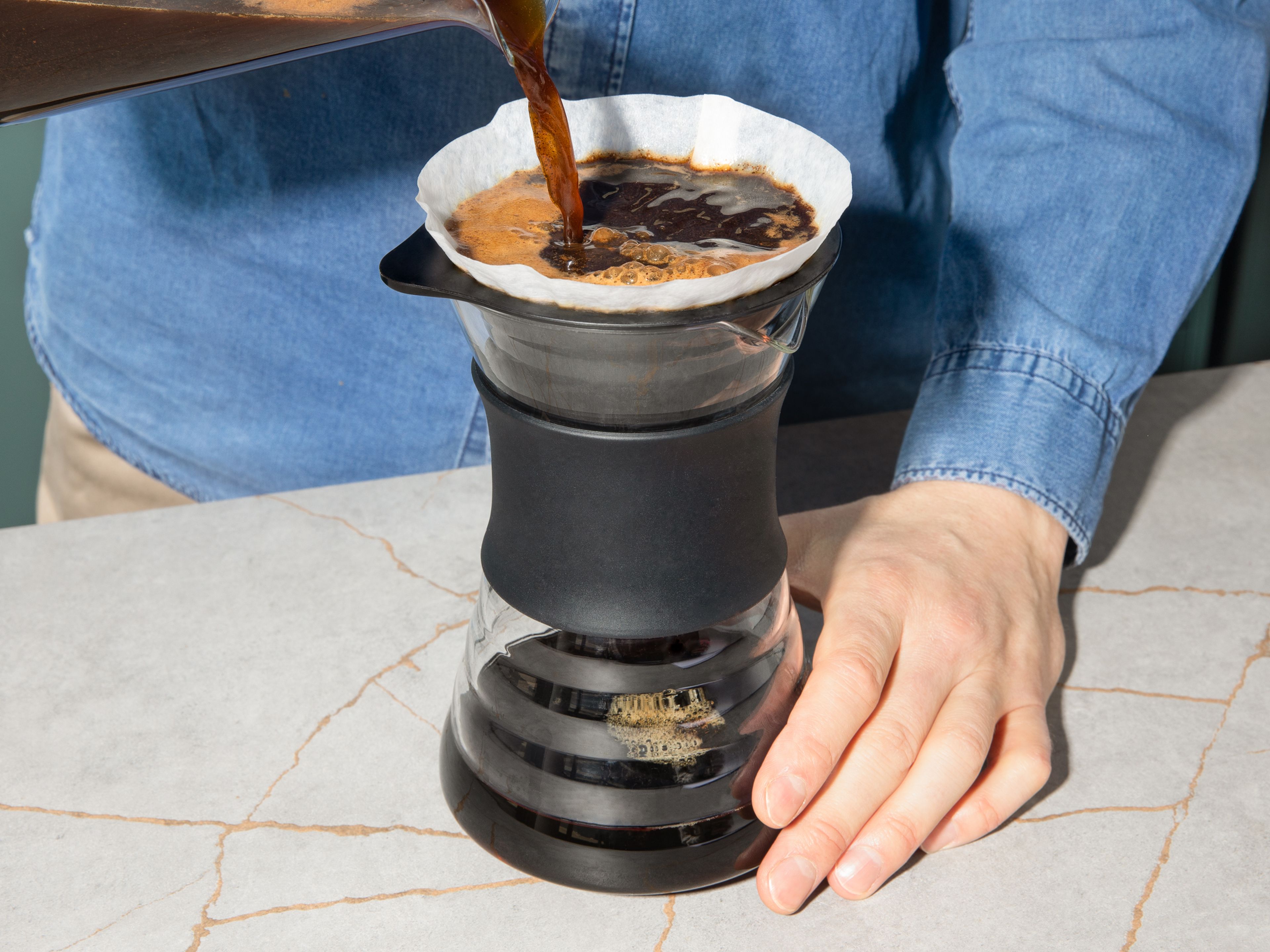 Nach der Ziehzeit den Kaffee aus dem Kühlschrank nehmen und über einen weiteren Messbecher durch einen Kaffeefilter geben, bspw. platziert in einem Sieb oder einem Handfilter. Kurz beiseitestellen.
