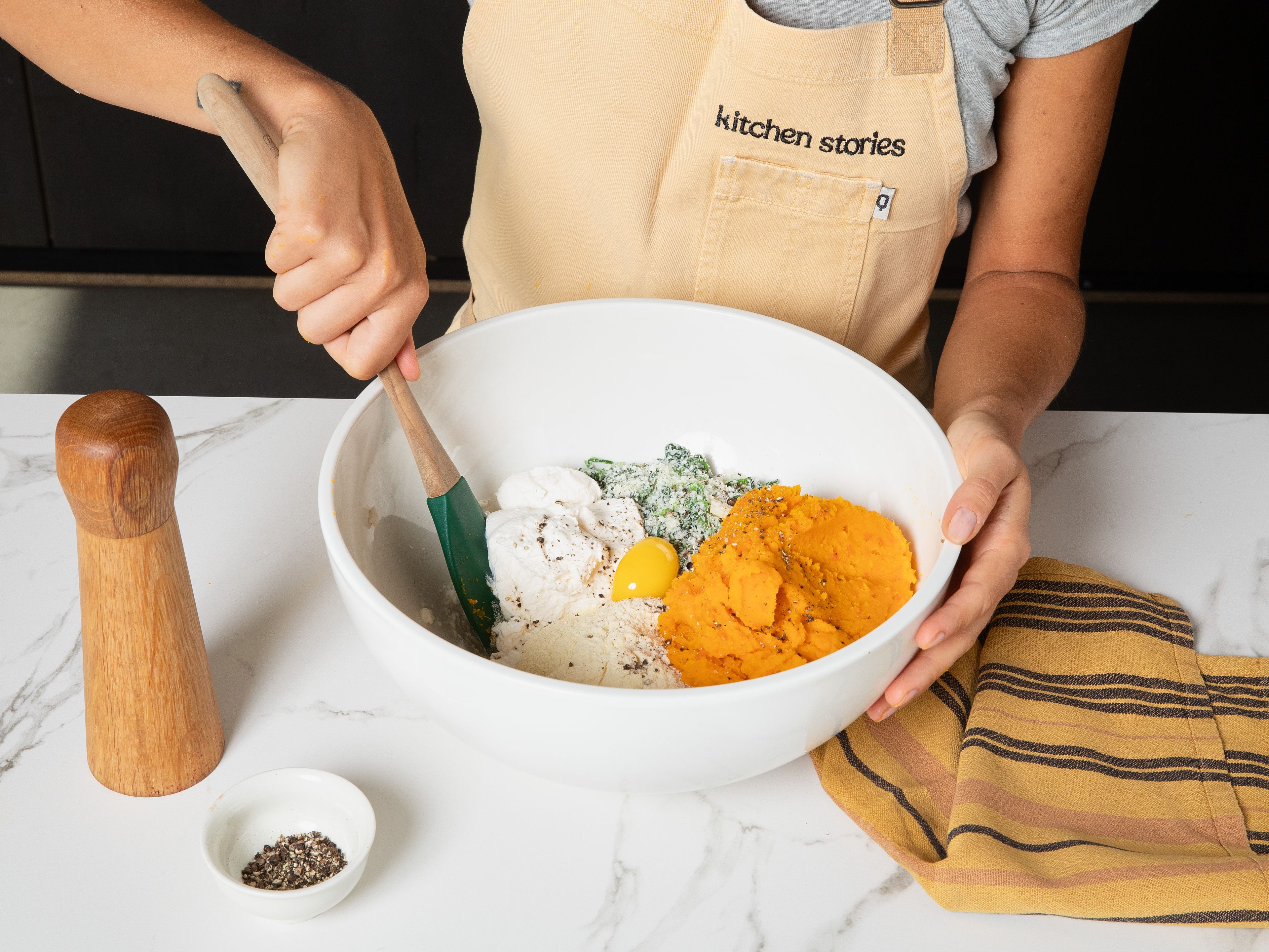 In der Zwischenzeit Spinat in kochendem Wasser ca. 1 Min. blanchieren, abschrecken und überschüssiges Wasser gründlich ausdrücken. Anschließend fein hacken und geriebenen Parmesan unterheben. Den Spinat-Mix in einer großen Schüssel mit Ricotta, Eigelb, Hartweizengrieß und dem Kürbispüree vermengen und mit Salz und Pfeffer würzen. Zu einem gleichmäßigen Teig verarbeiten.