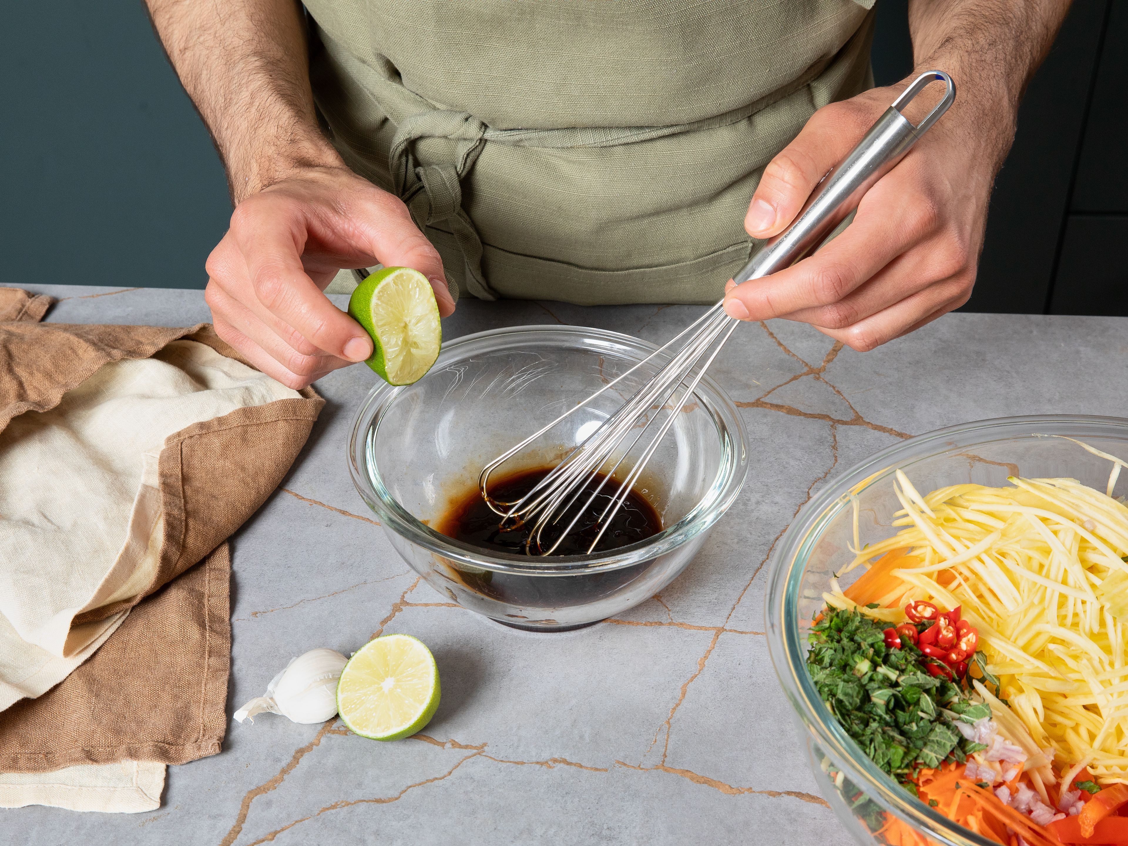 For the dressing, finely grate garlic, then add to a bowl. To the same bowl, add sweet chili sauce, lime juice, and soy sauce. Whisk everything well.