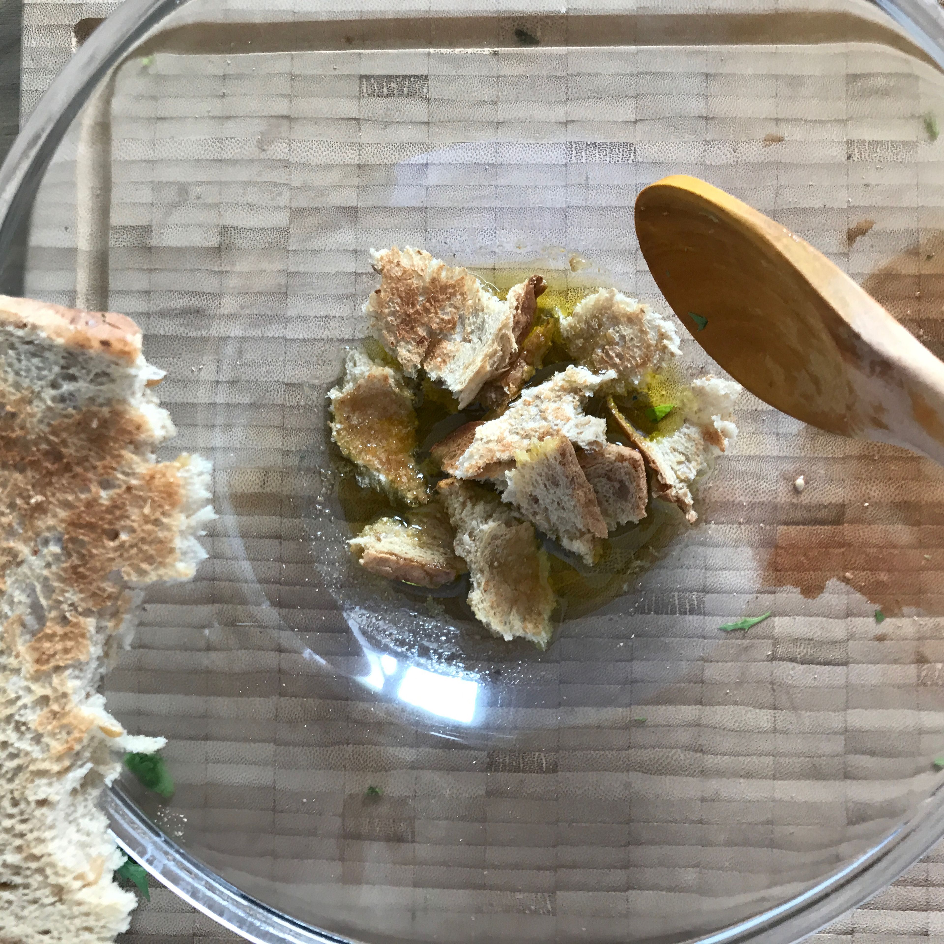 4 EL kaltgespresstes natives Olivenöl in eine große Salatschüssel geben. Getoastetes Brot mit der Hand in Stücke zupfen, in die Schüssel geben und einmal mit dem Öl durchmengen.
