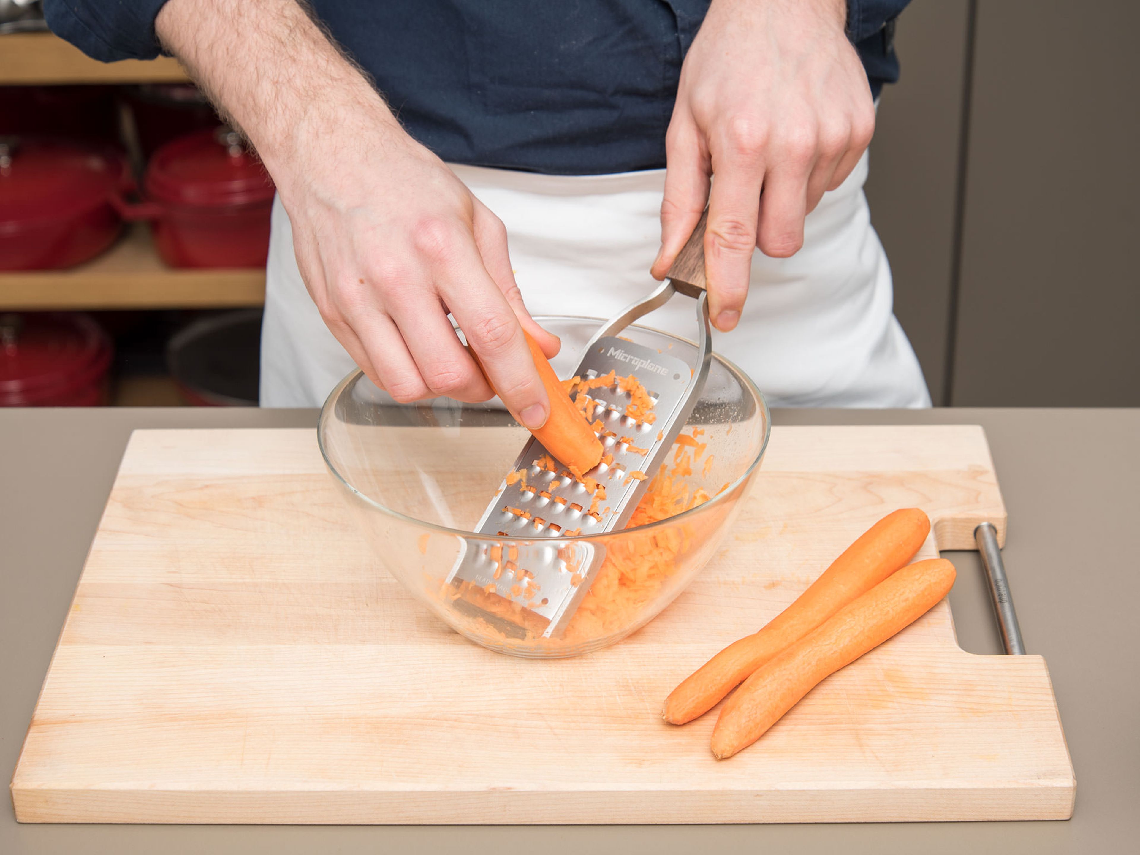 Backofen auf 170°C vorheizen. Springform mit Butter einfetten. Karotten schälen, reiben und beiseitestellen. Eier in zwei kleine Schüsseln trennen.