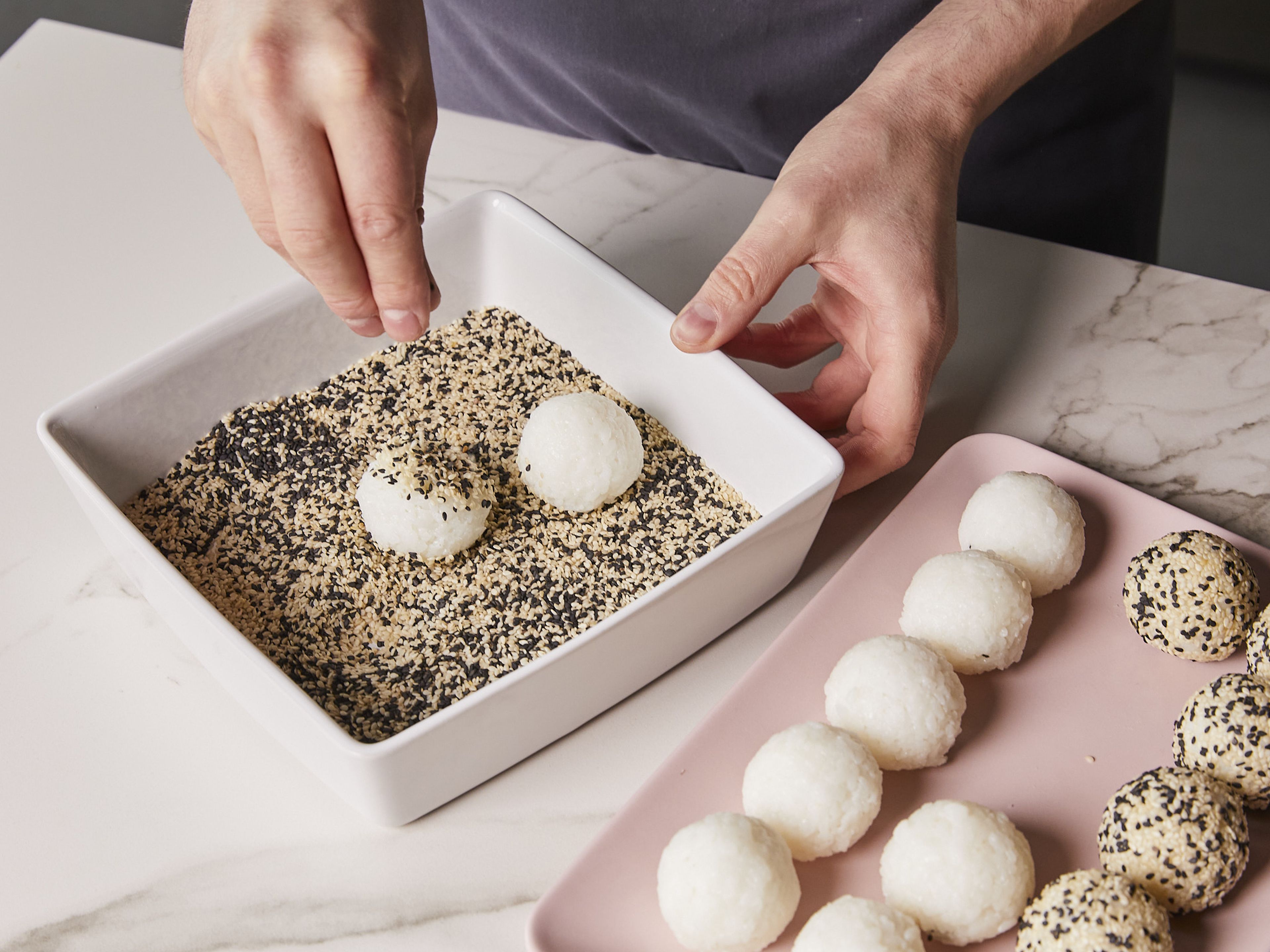 Put the sesame seeds on a flat plate and roll the finished balls around to coat them. Cut the scallion into fine rings. Arrange sushi balls on a plate and garnish with mayonnaise, teriyaki sauce and spring onion rings as desired. Serve with soy sauce and wasabi.
