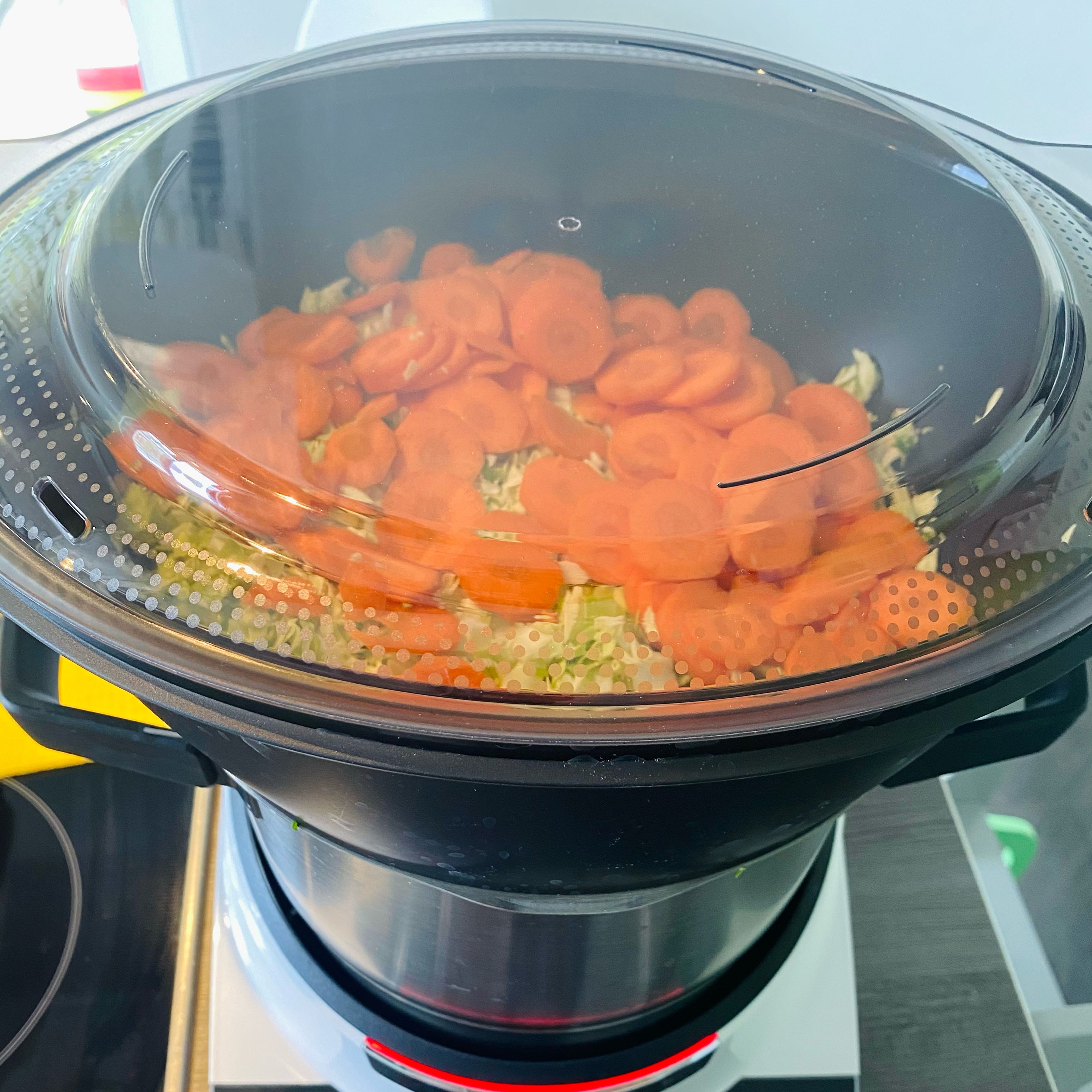 Das Automatikprogramm für Dampfgaren (Hohe Dampfintensität) auswählen. Den Dampfgardeckel auflegen und die Zutaten (15 Min.) dämpfen lassen. - Das Wasser in den Topf geben, Dampfgareinsatz einsetzen, Messbecher entfernen und dämpfen (Dampfgareinsatz | Automatikprogramm | Hohe Intensität | 15 min).