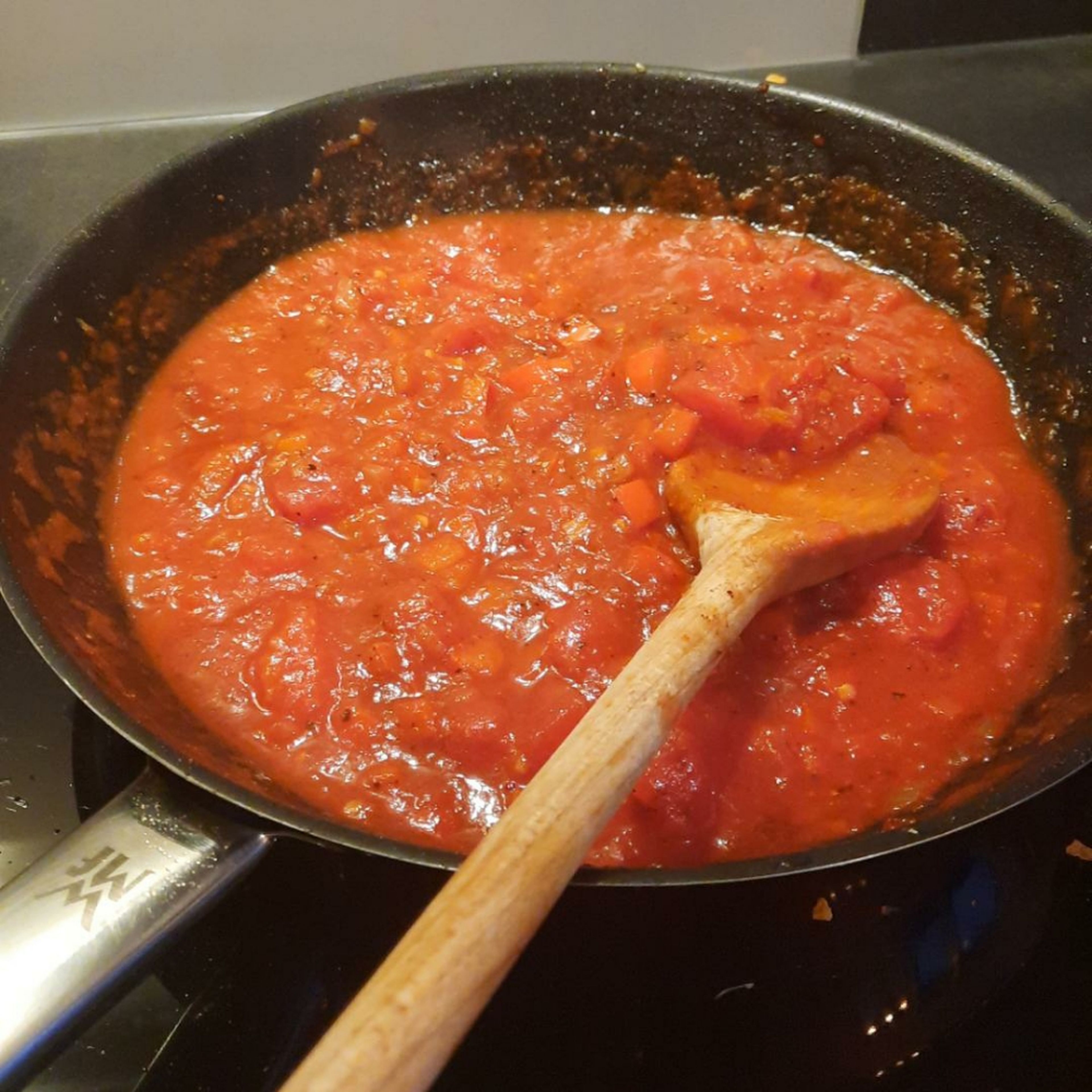 Add tomato paste and sugar into the pan and keep sautéing, approx. 2 min. Deglaze with red wine. Add crushed tomatoes and simmer for approx. 7 – 10 min. Season to taste with salt, pepper, and chili powder.