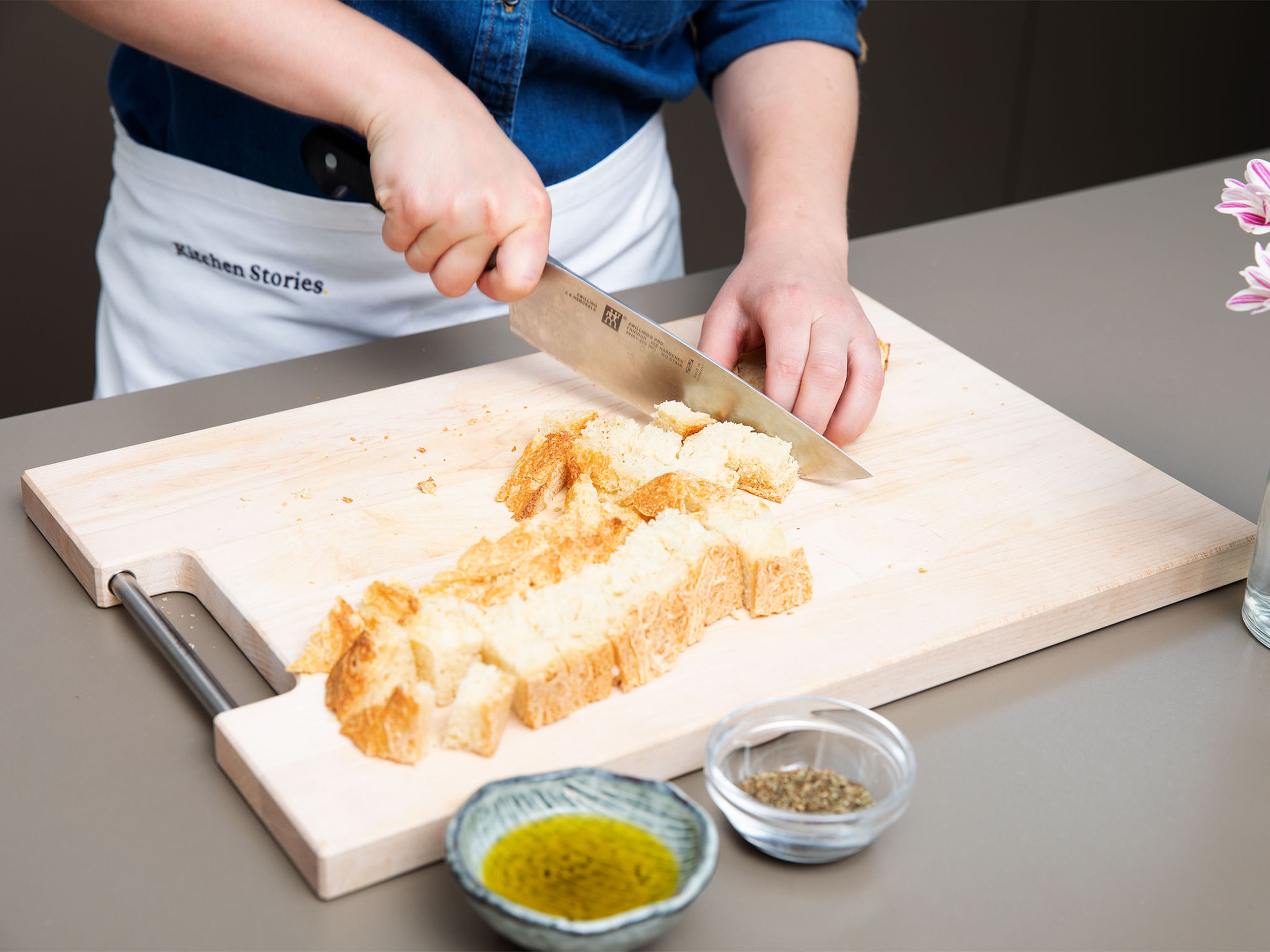 Preheat oven to 180°C/350°F. Cut the two slices of bread into cubes. Transfer to a bowl, add olive oil and dried basil, and toss until evenly coated. Transfer to a baking sheet and bake for approx. 8 – 10 min. or until golden.