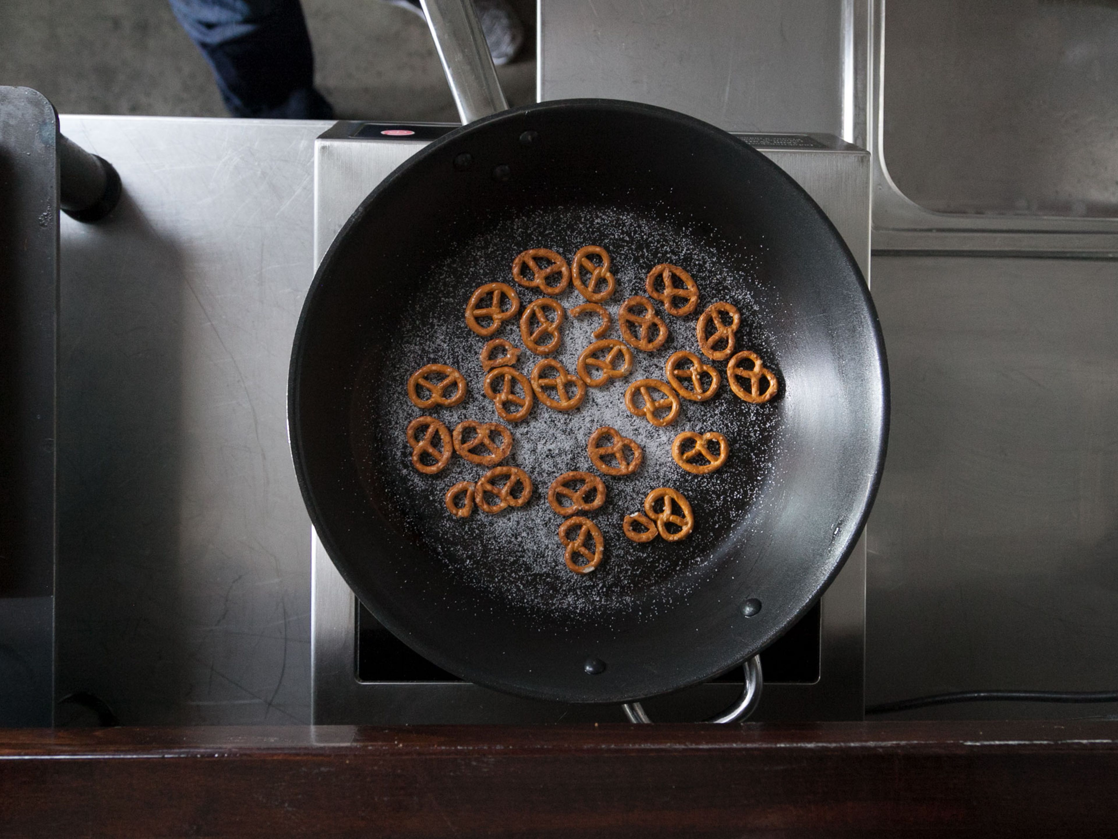 In a nonstick pan, caramelize salty pretzels with sugar over medium heat; be careful not to let sugar burn. Remove from heat and let cool. Remove caramelized pretzels from pan and roughly chop.