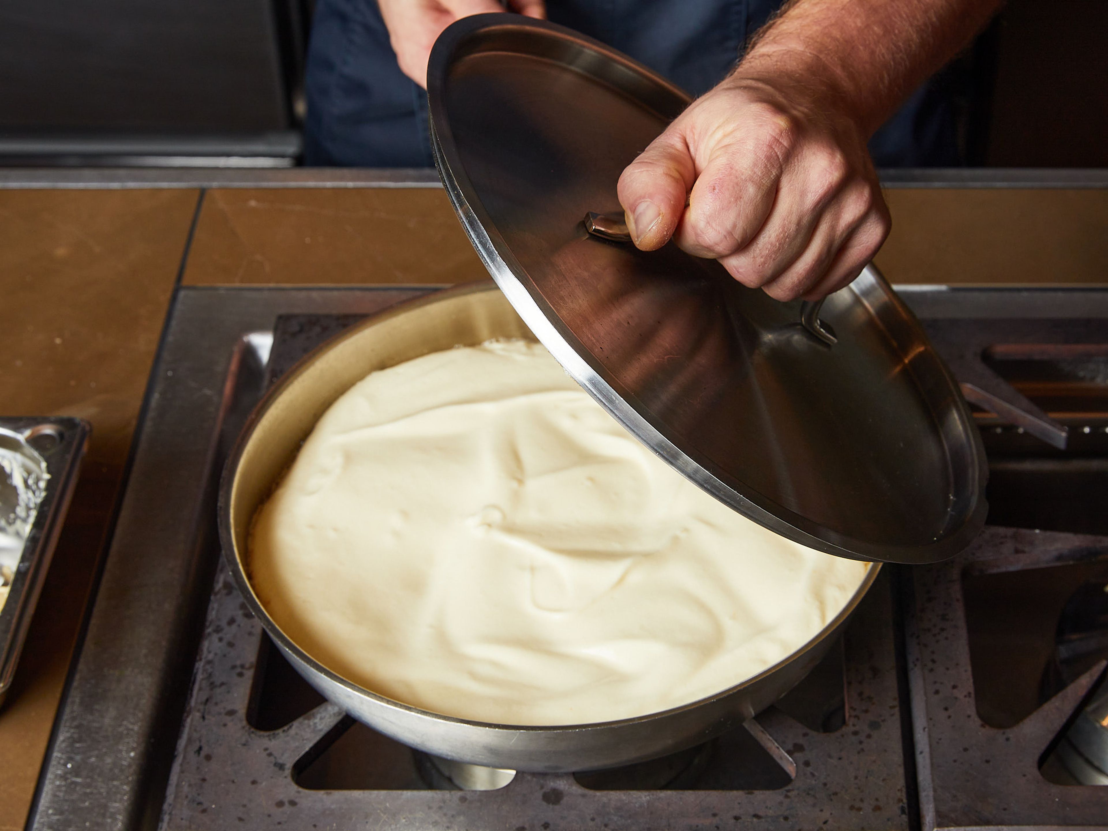 Eine beschichtete Pfanne mit 2 Esslöffel Butter auf mittlerer Hitze erwärmen, bis die Butter geschmolzen ist. Den Teig in der Pfanne verteilen und den Deckel auf die Pfanne geben.