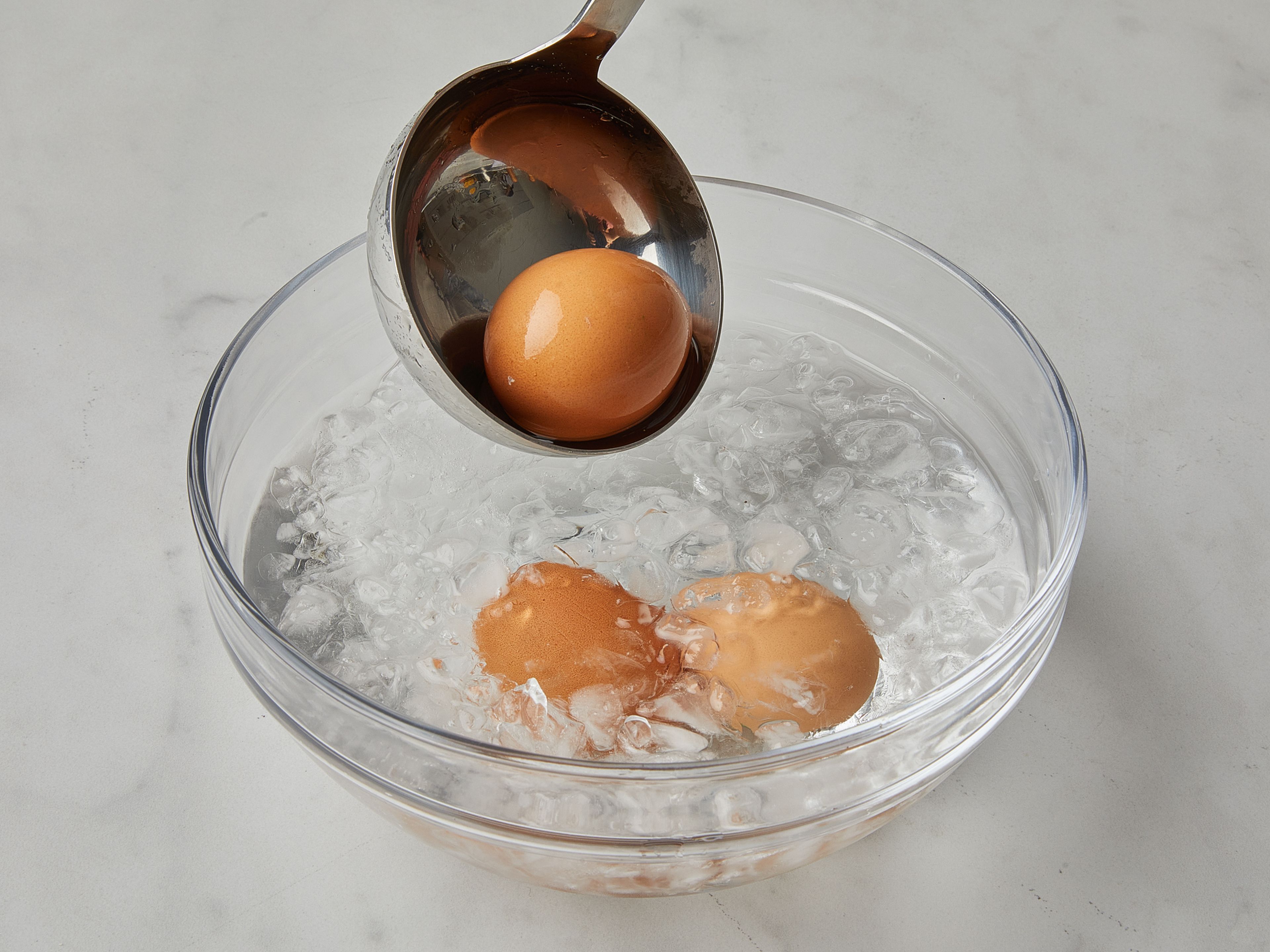 Die Eier auf Zimmertemperatur bringen. Einen Topf mit Wasser zum Köcheln bringen. Die Eier mit einer Schöpfkelle vorsichtig hineingeben und ca. 6 Min. köcheln lassen. Danach die Eier sofort in eine Schüssel mit Eiswasser geben, um den Kochprozess zu stoppen.