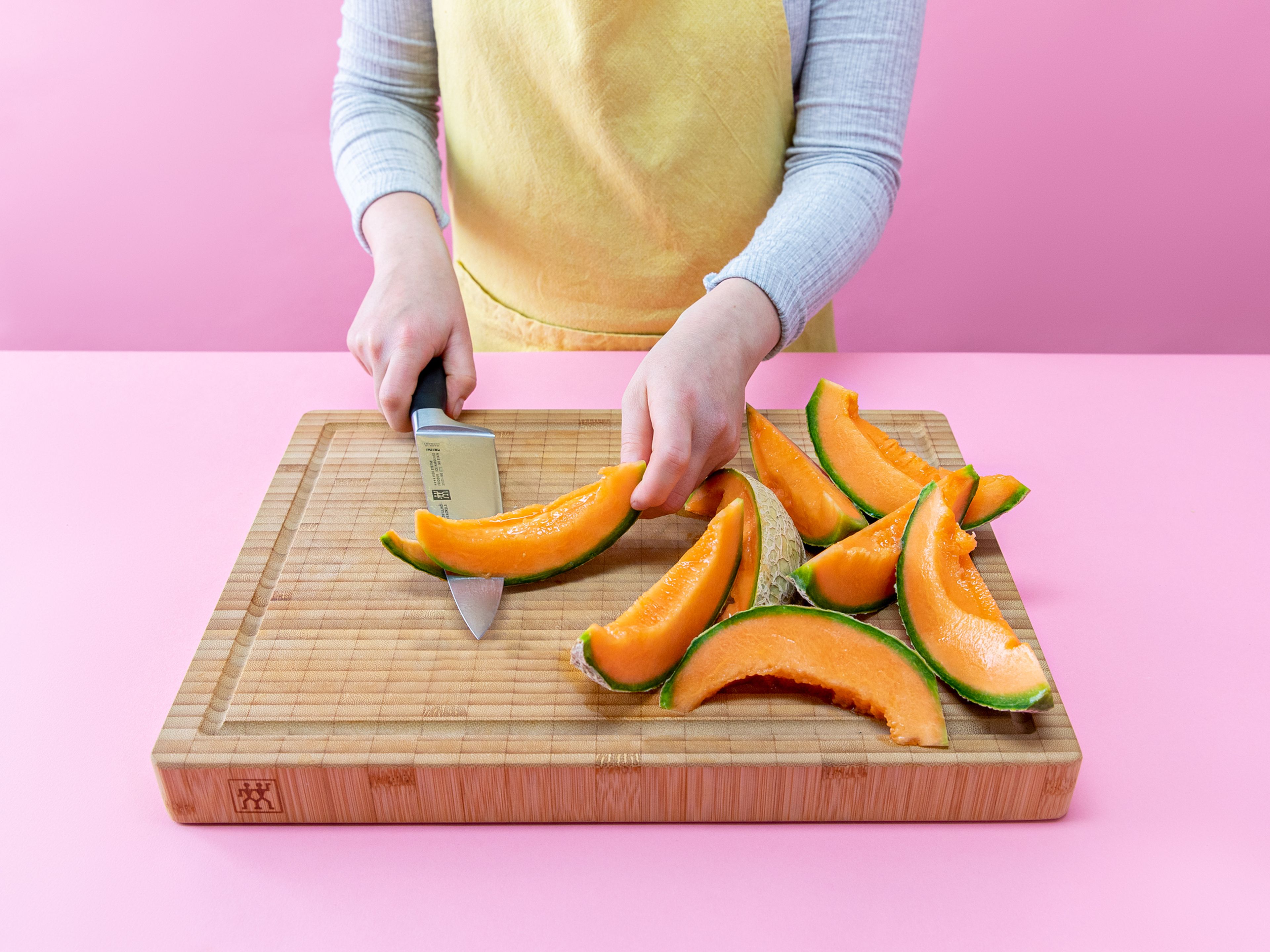 Die Melone halbieren und die Kerne mit einem Löffel entfernen. Jede Hälfte in 6 Spalten schneiden und die Schale mit einem Messer entfernen.