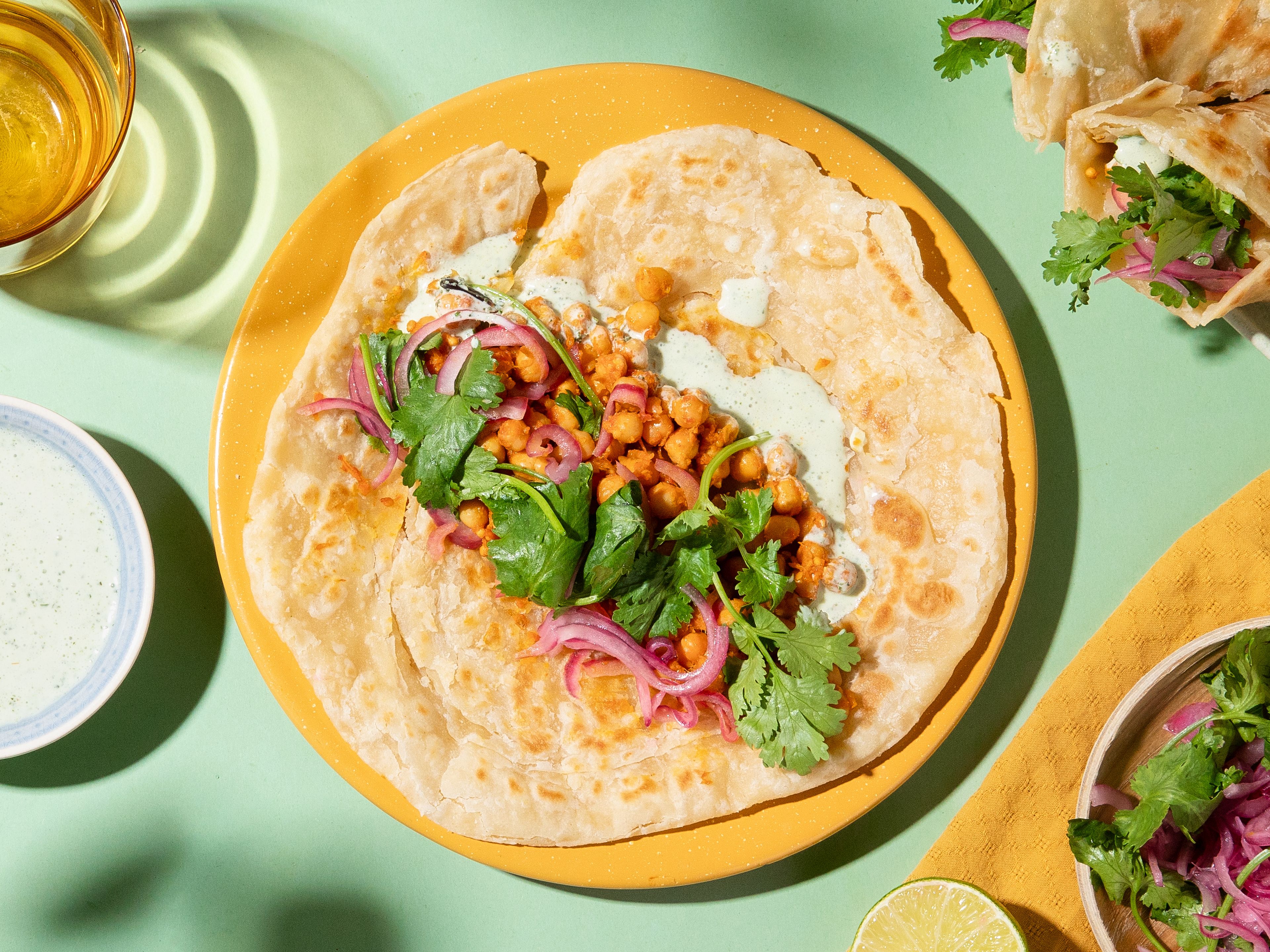 Paratha-Wraps mit Kichererbsen, eingelegten Zwiebeln und Raita
