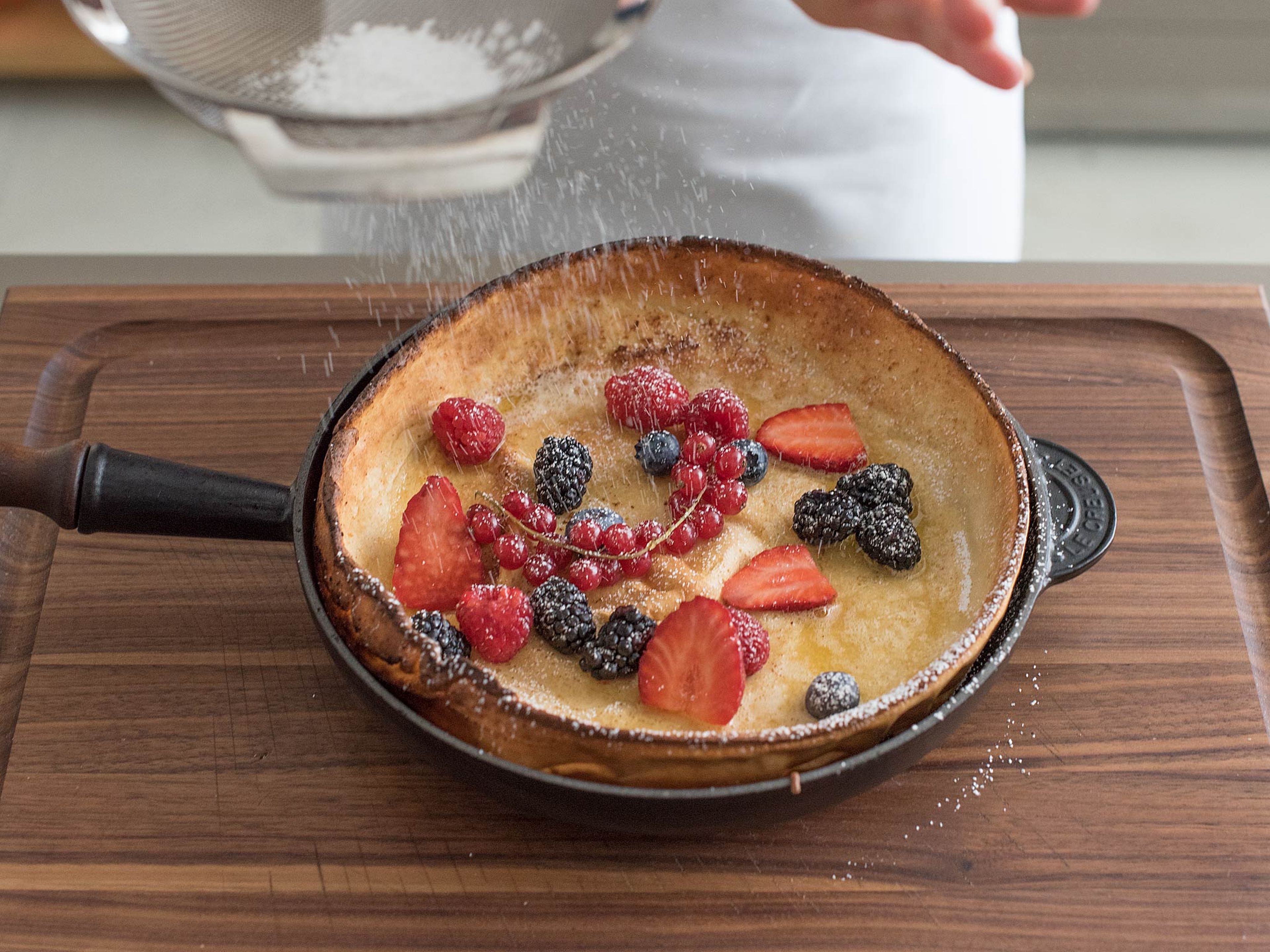 Slide Dutch baby onto serving platter or cutting board, or serve straight from pan, if desired. Top with fresh berries and sprinkle with lemon juice. Dust with confectioner's sugar and cut into wedges for serving. Serve warm with maple syrup.