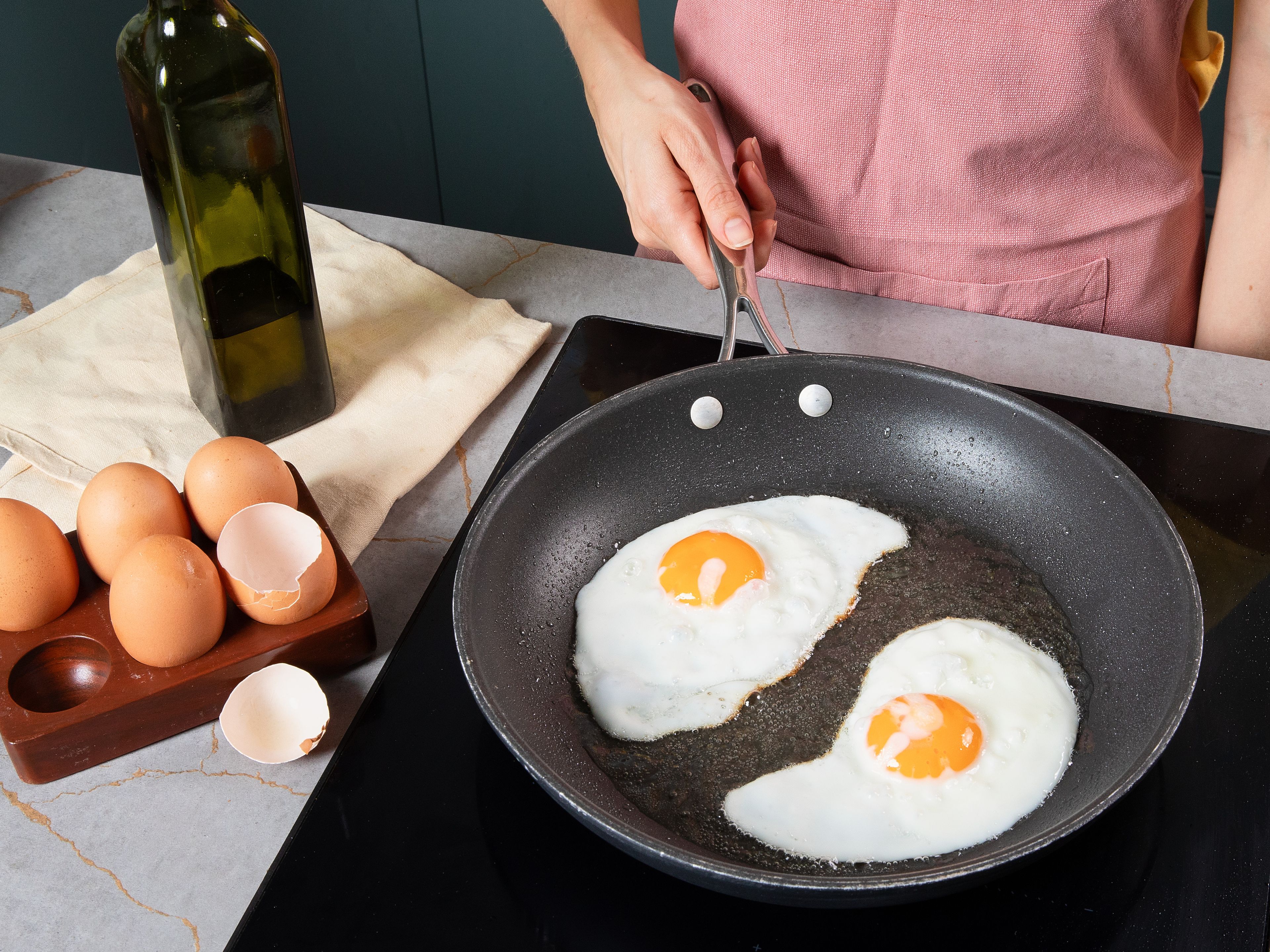 Heat some olive oil in another pan. Carefully crack in eggs and fry over medium heat until the whites are set but the yolks are still soft. Season with salt and pepper.