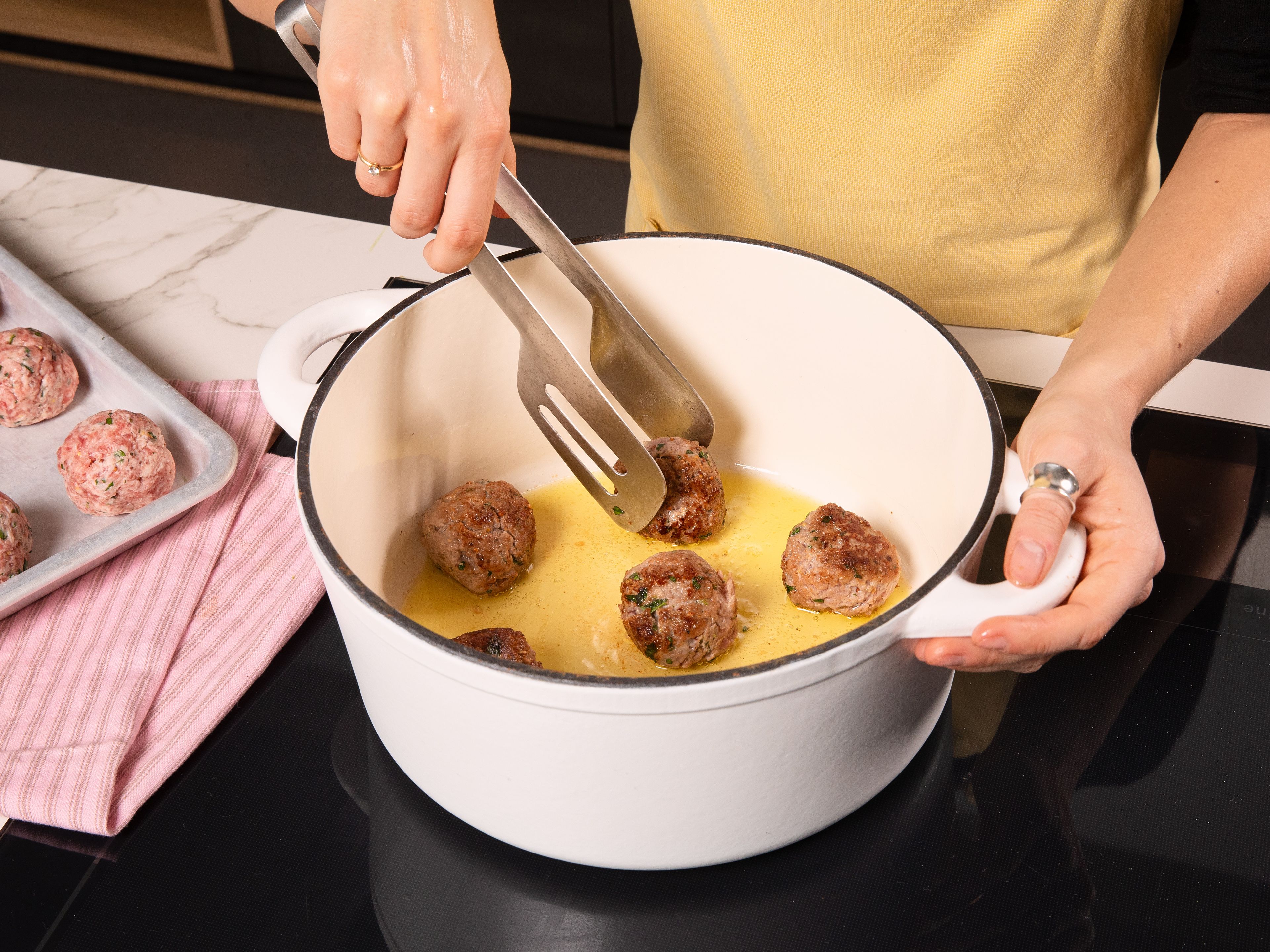 Heat a little olive oil in a large pot over medium-high heat. Add the meatballs and brown them on all sides for approx. 5–7 min., until golden brown. Remove from the pot and set aside. In the same pot, add a drizzle of olive oil. Sauté the shallots, garlic and half of the fennel for approx. 3 min., until slightly softened. Add a few slices of lemon and a pinch of chili flakes, season with salt and pepper and fry briefly, until the lemon develops some dark spots. Deglaze with stock and water and bring to a boil. Reduce the heat, return the meatballs to the pot and let simmer gently, covered, for approx. 15 min.