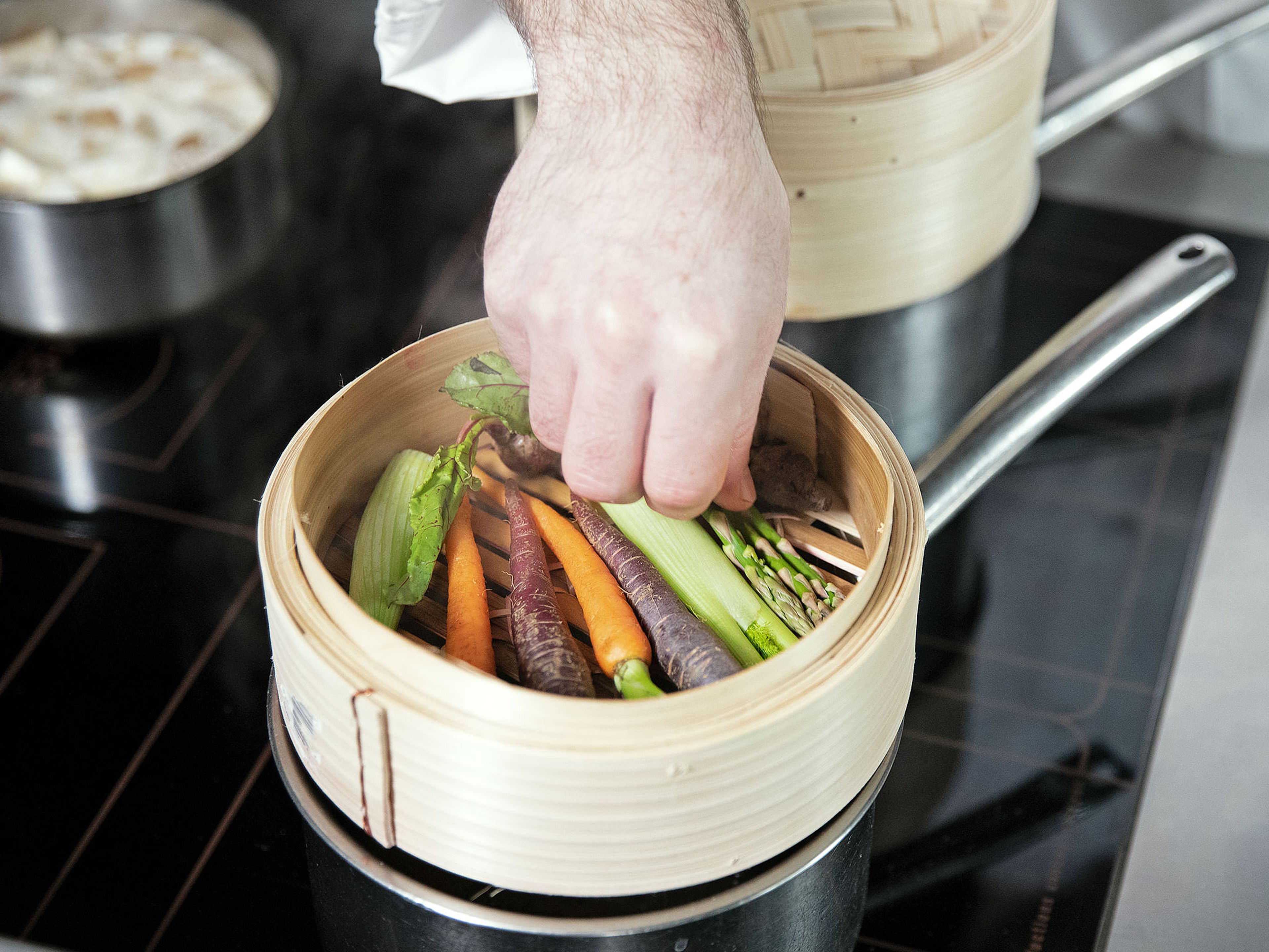 In two separate saucepans, each with a bamboo steamer on top, bring water to a boil. Prepare baby red peppers, baby zucchinis, baby corns, shiitake mushrooms, baby carrots, baby bok choy, baby fennel, and green asparagus. Add all vegetables to the bamboo steamers and steam for approx. 12 min.