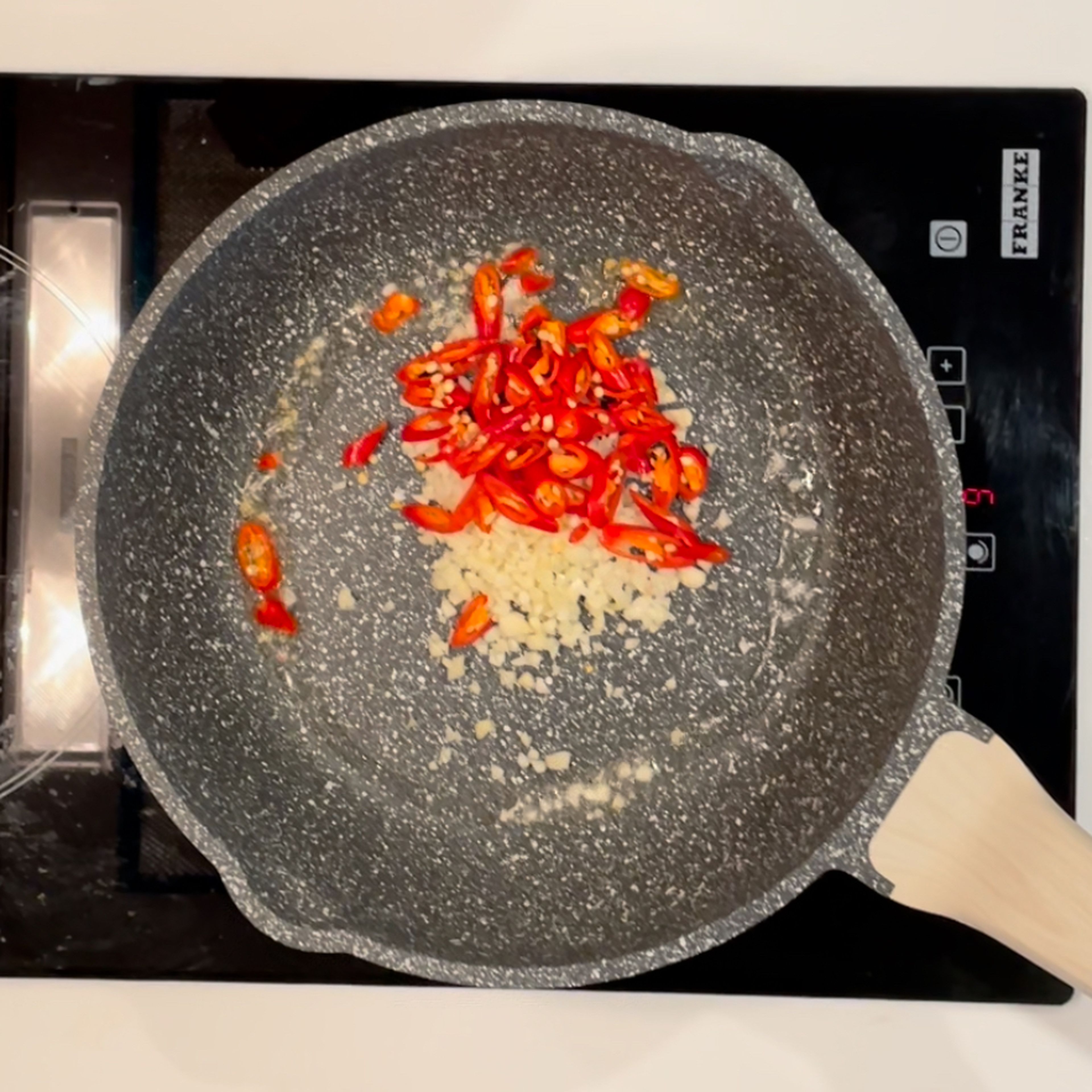 To make Pad Kra Pao, Heat your wok on high heat. Add vegetable oil until oil is hot, add the chilies and garlic. Stir fry until the garlic starts to turn golden. Add chicken and toss until they're no longer in big clumps.