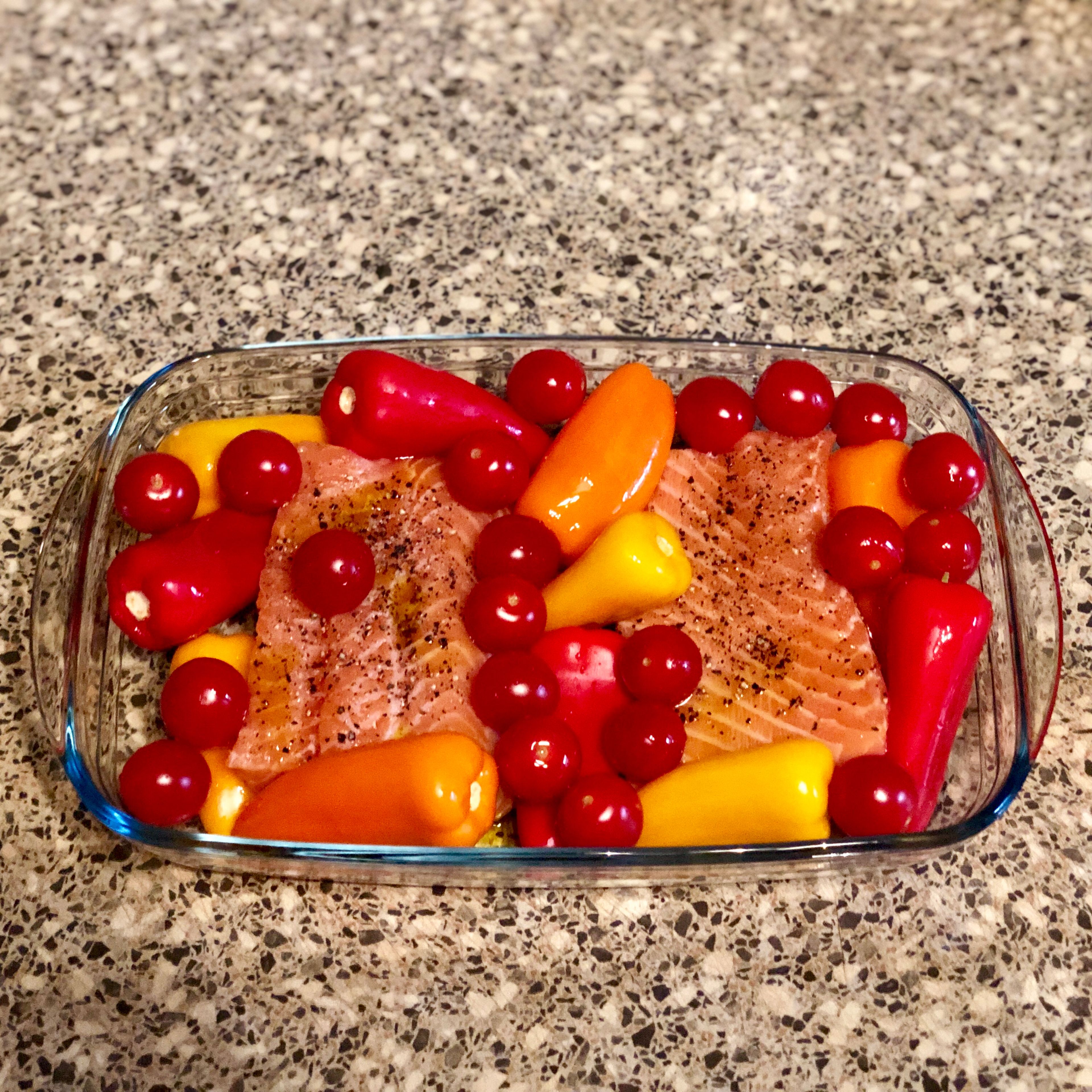 Place salmon, bell peppers and cherry tomatoes in a glass bakeware (baking dish).