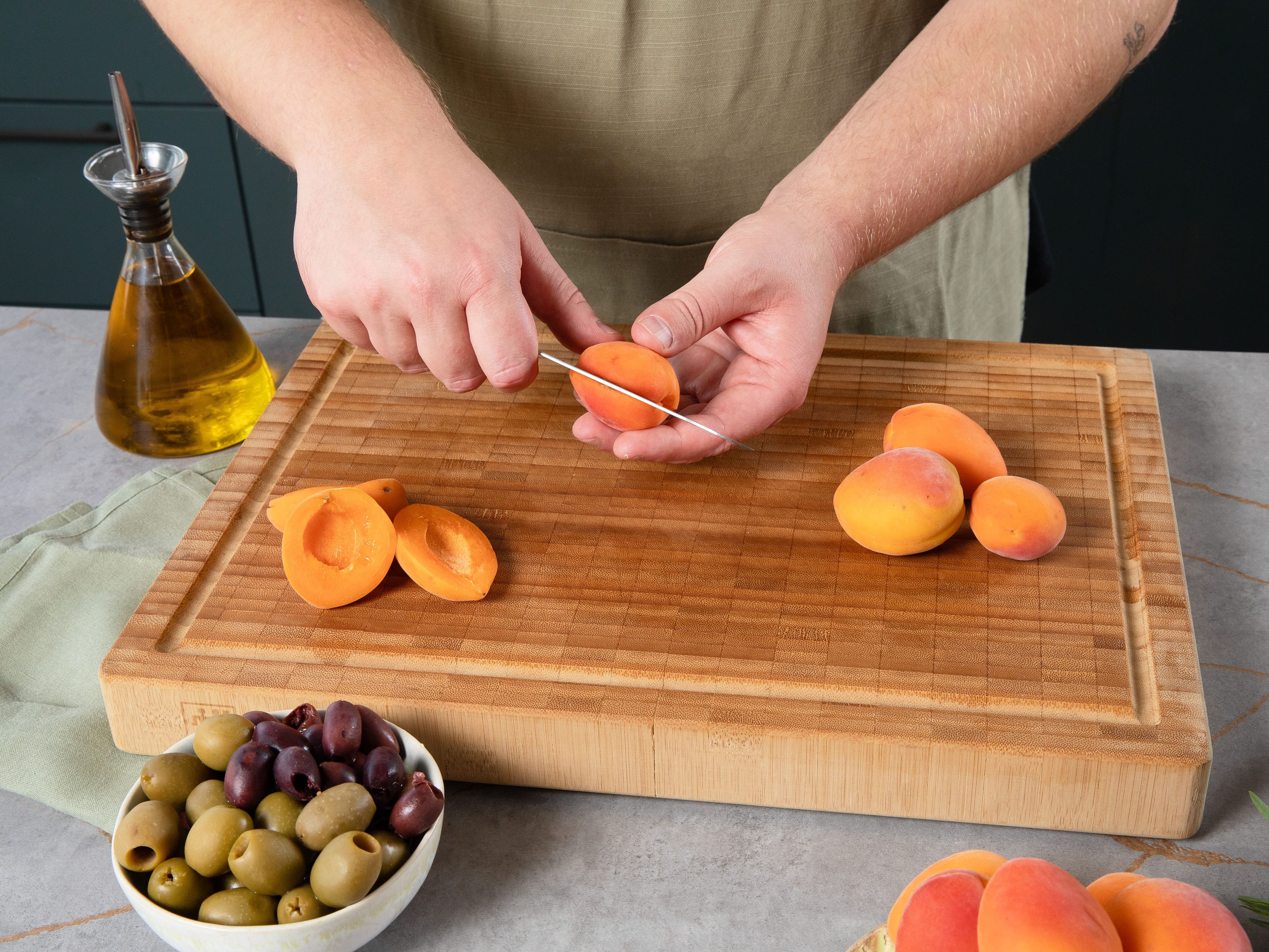 Preheat oven to 200°C/ 390°F. Pit and halve apricots. Slice lemons. Finely dice shallots, chop garlic. Finely chop half of tarragon. Cut olives into fine rings and mix with shallots, garlic, olive oil, finely chopped tarragon, and some salt in a small bowl.