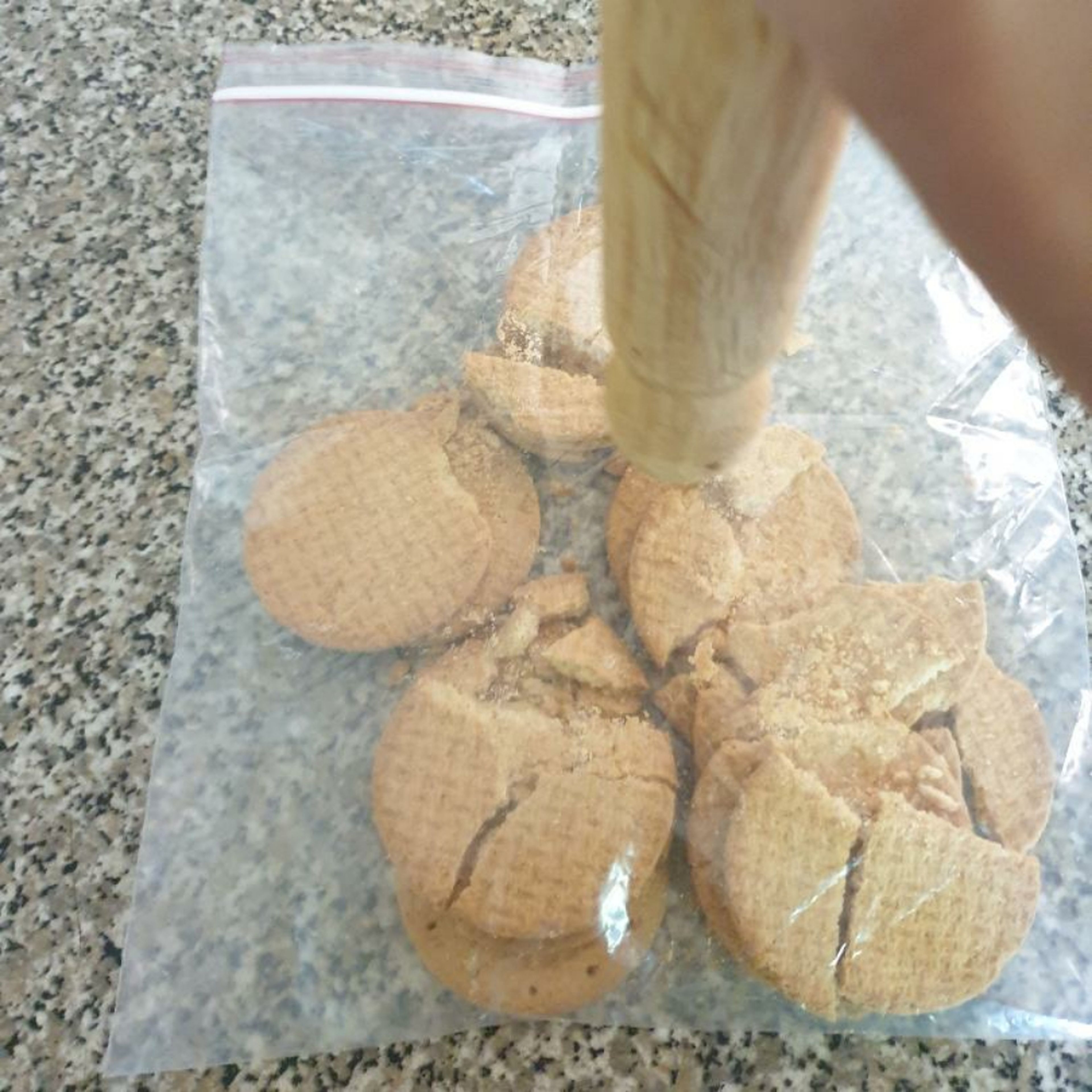Crush the biscuits in a freezer bag, using a rolling pin.