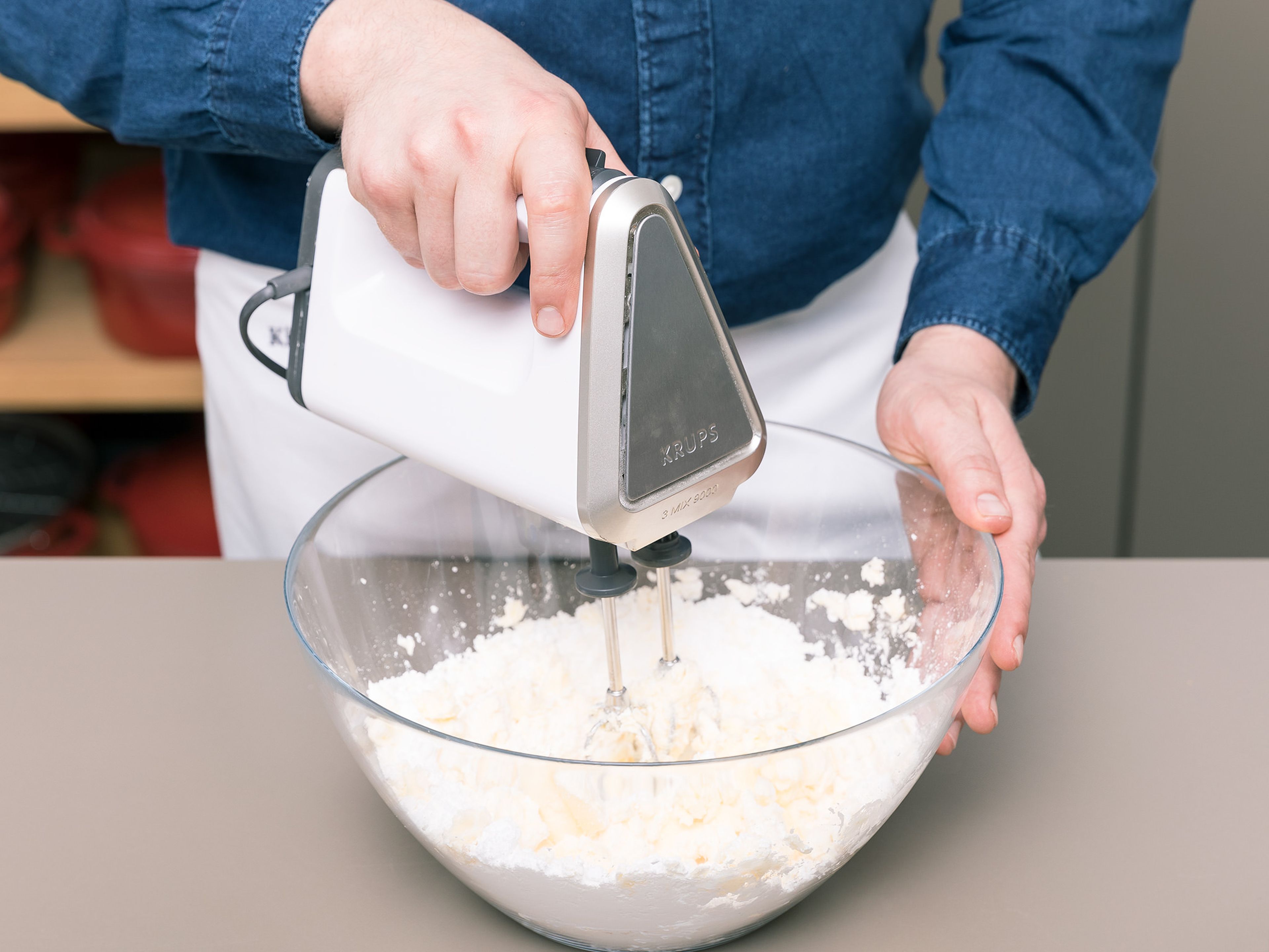 Backofen auf 175°C vorheizen. Eine Backform einfetten und mit Mehl bestäuben. In einer Schüssel den Großteil der Butter und des Puderzuckers mit der Hälfte des Vanilleextrakts und Salz schaumig schlagen. Die Eier nach und nach unterrühren. In einer separaten Schüssel Mehl und Backpulver vermengen. Schrittweise die Mehl-Backpulver-Mischung und die Kamillen-Milch zur Butter-Mischung geben und vermengen. Die eingeweichten Kamillenteeblätter abgießen, in den Teig geben und alles sorgfältig vermengen.