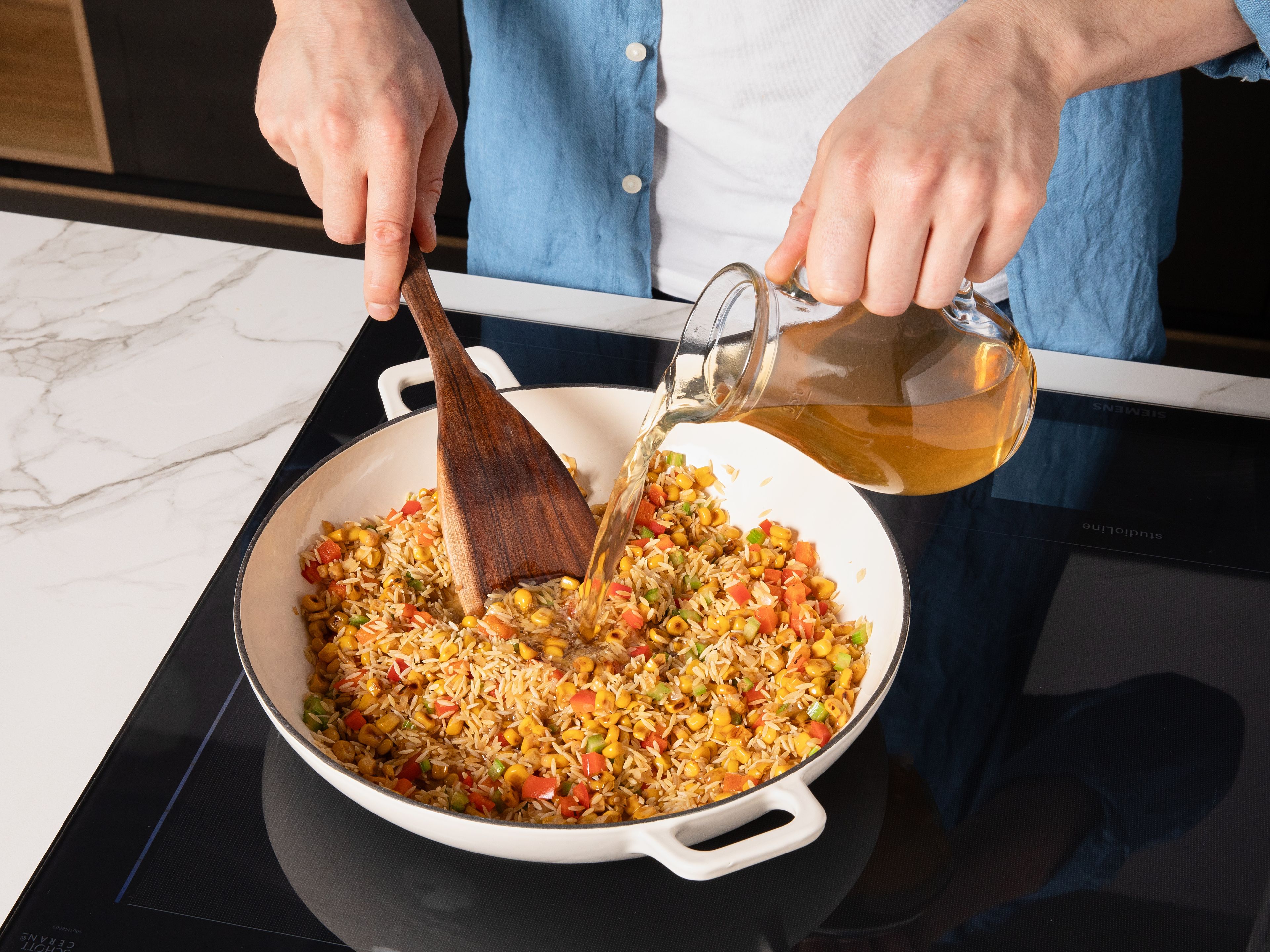 Orzo zum Gemüse in den Topf geben, kurz mitrösten und mit Gemüsebrühe und Kochsahne ablöschen. Alles umrühren, aufkochen und zugedeckt bei mittlerer Hitze ca. 10–12 Min. köcheln lassen, bis die Nudeln gar und die Flüssigkeit größtenteils aufgenommen ist. Die Garnelen zurück in den Topf geben und ca. 2–3 Min. bei niedriger Hitze ziehen lassen. Eine Limette auspressen, die andere in Spalten schneiden. Die Orzo-Pfanne mit Limettensaft, gehackter Petersilie, Salz und Pfeffer abschmecken, ca. 5 Min. ruhen lassen und mit den Limettenspalten servieren.