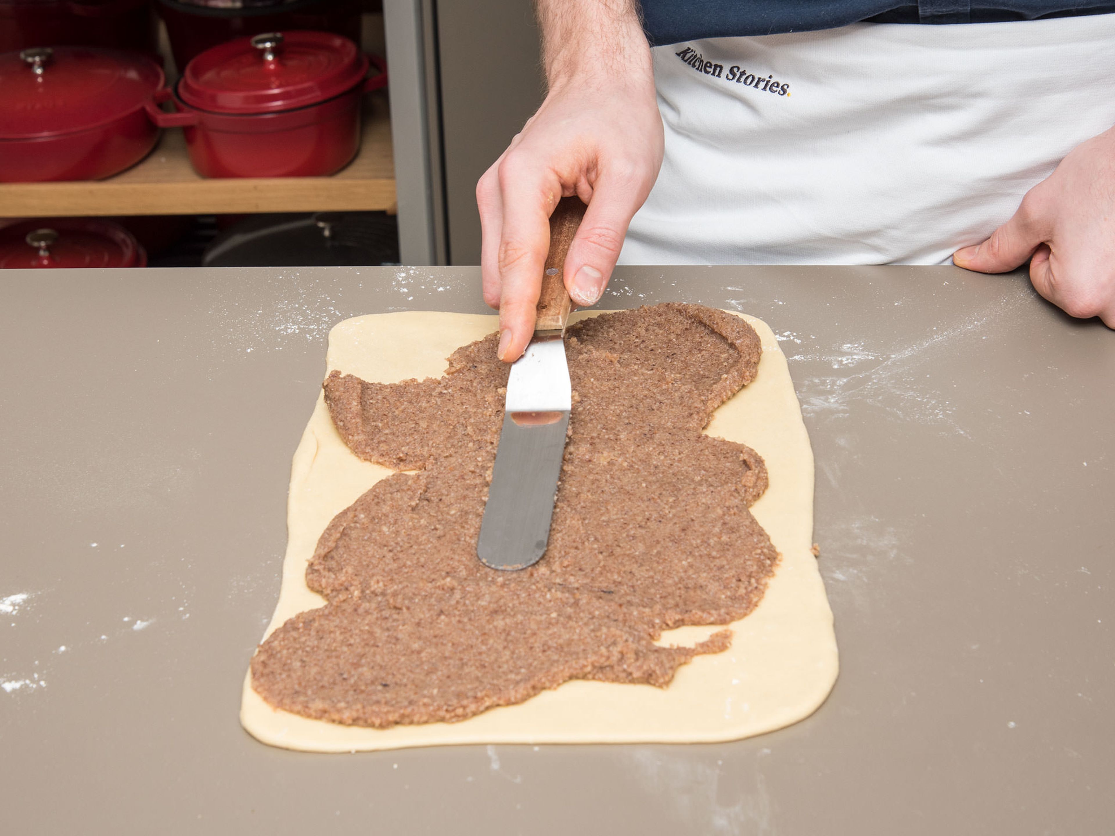Backofen auf 160°C vorheizen. Arbeitsfläche mit Mehl bestäuben. Den Teig zu einem Rechteck von ca. 40 x 50 cm ausrollen und die Nussfüllung mit einer Palette auf dem Teig verteilen.