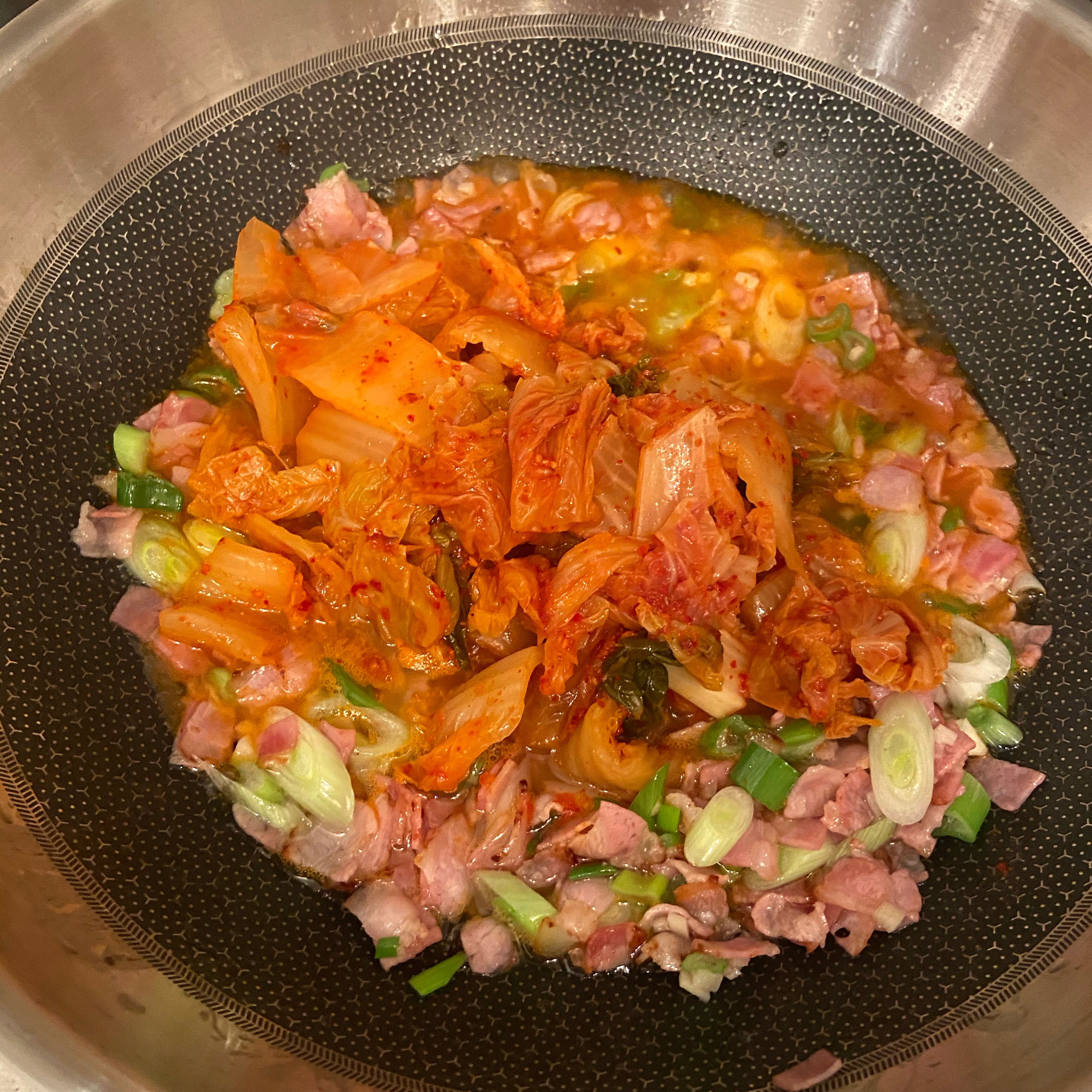 Kimchi und klein geschnittene Frühlingszwiebeln dazugeben und nochmal ca. 5 min. einreduzieren lassen.