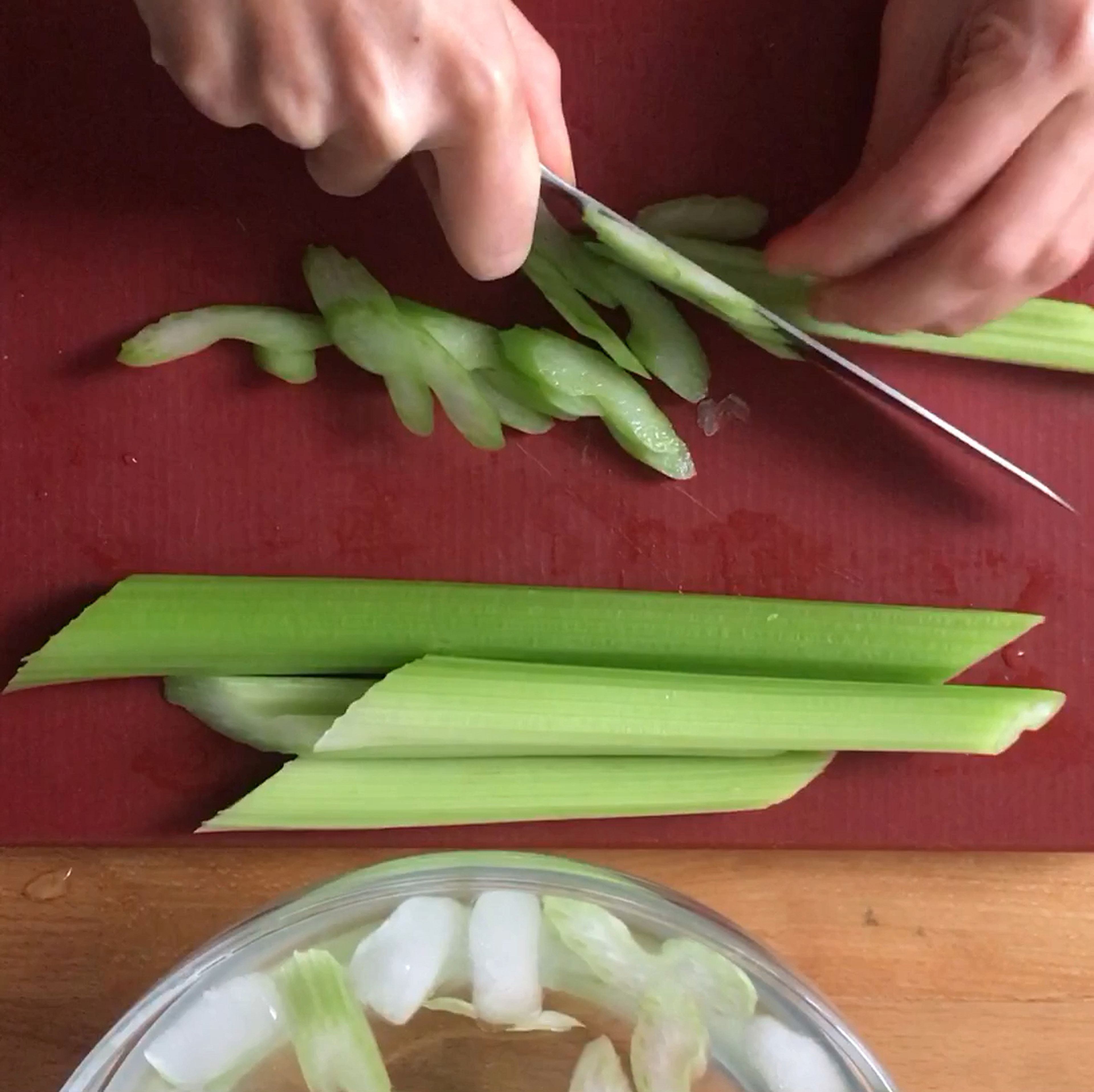 Slice celery stalks on the bias to create long, thin pieces. If your stalks have leaves, pluck them and set aside for later. Transfer the sliced celery to a bowl of cold water (iced is even better) and let soak while you prepare the other ingredients.