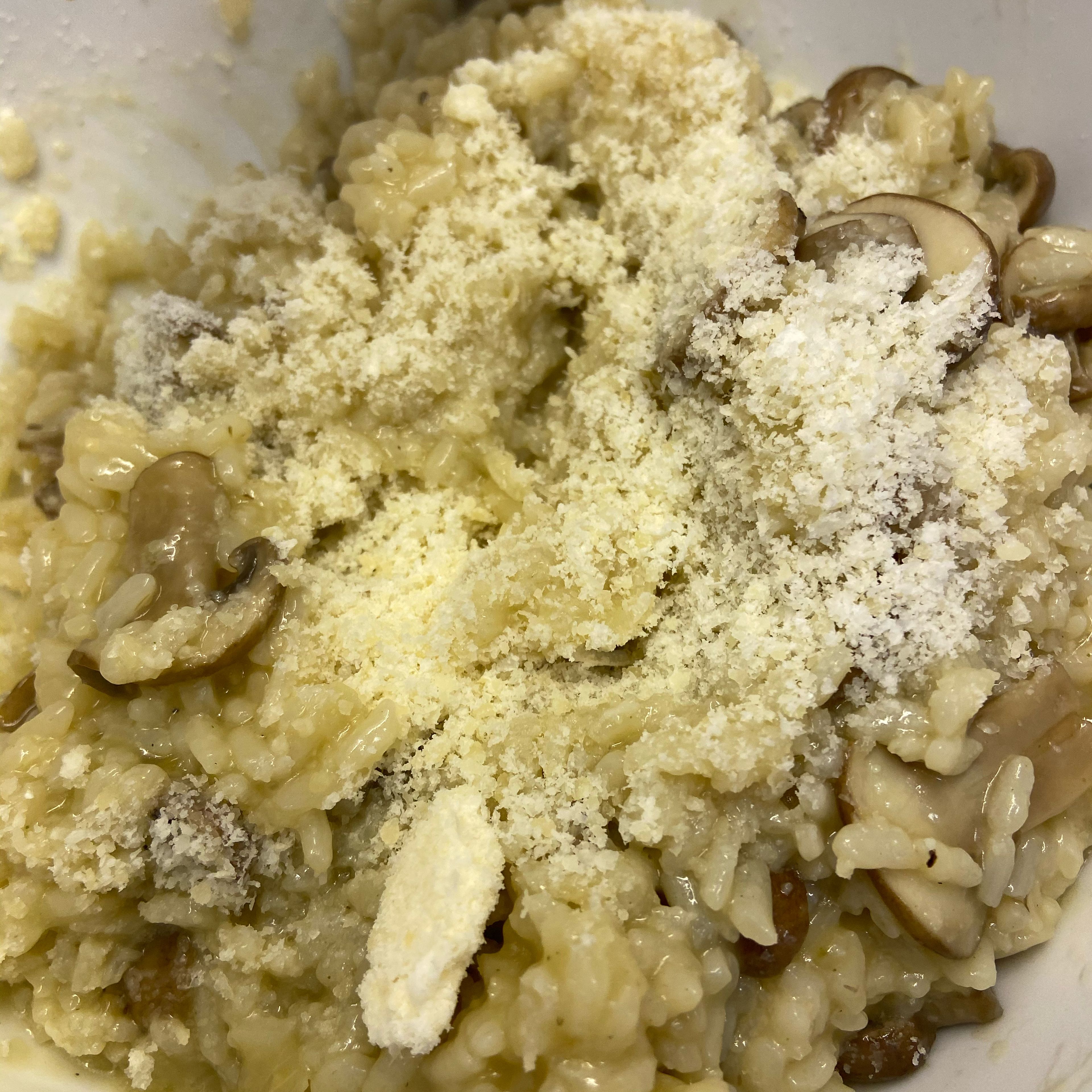 Die Risotto Masse in eine extra Schüssel geben und ca. 5 Minuten quellen lassen. Anschließend den geriebenen Parmesankäse unterheben.
