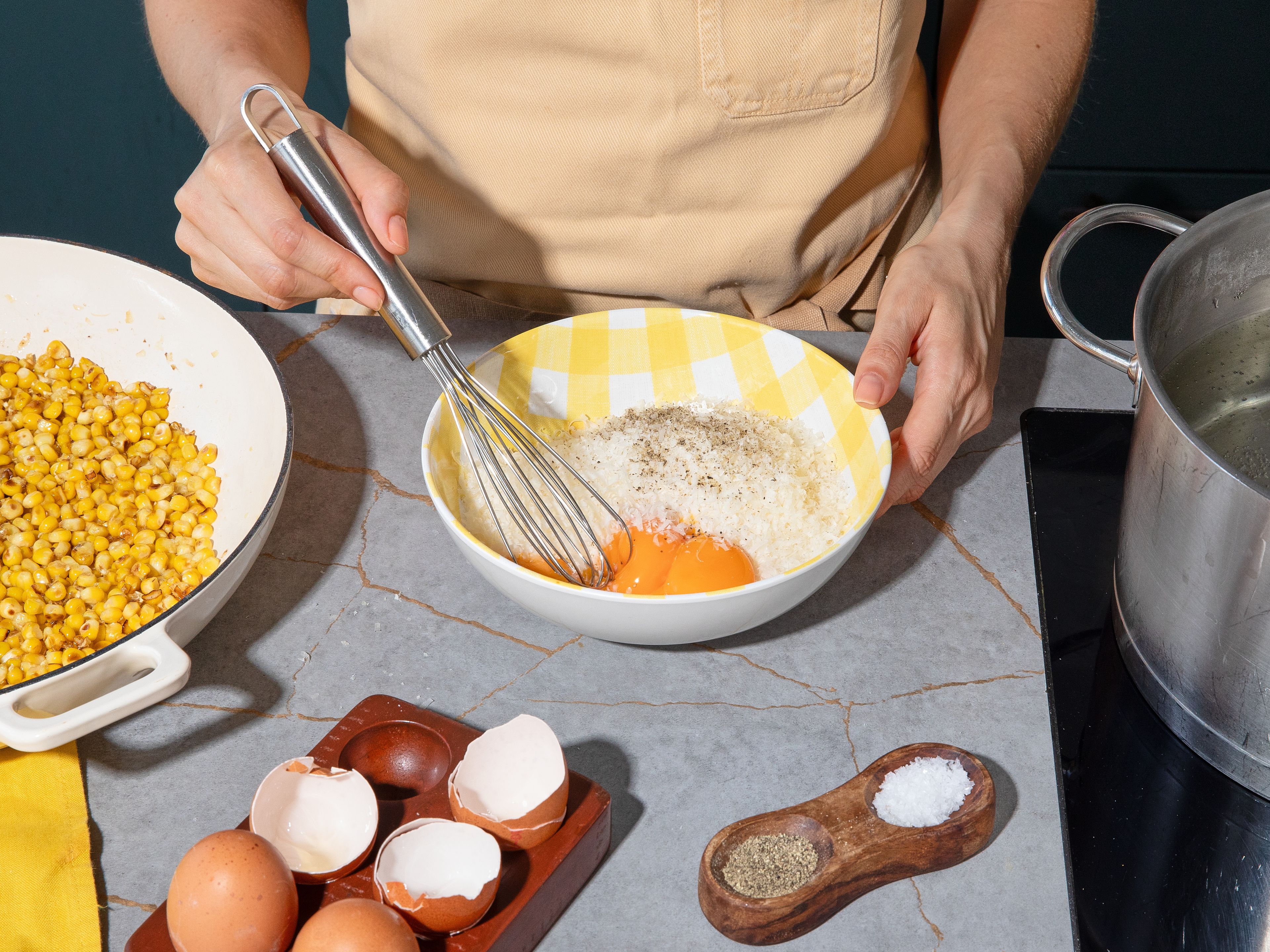 Die Pappardelle in reichlich Salzwasser nach Packungsanweisung al dente kochen. Danach Pasta abgießen und dabei etwas Kochwasser auffangen. Währenddessen Parmesan reiben und in einer kleinen Schüssel mit Eigelb, etwas Pastawasser und schwarzem Pfeffer verrühren.
