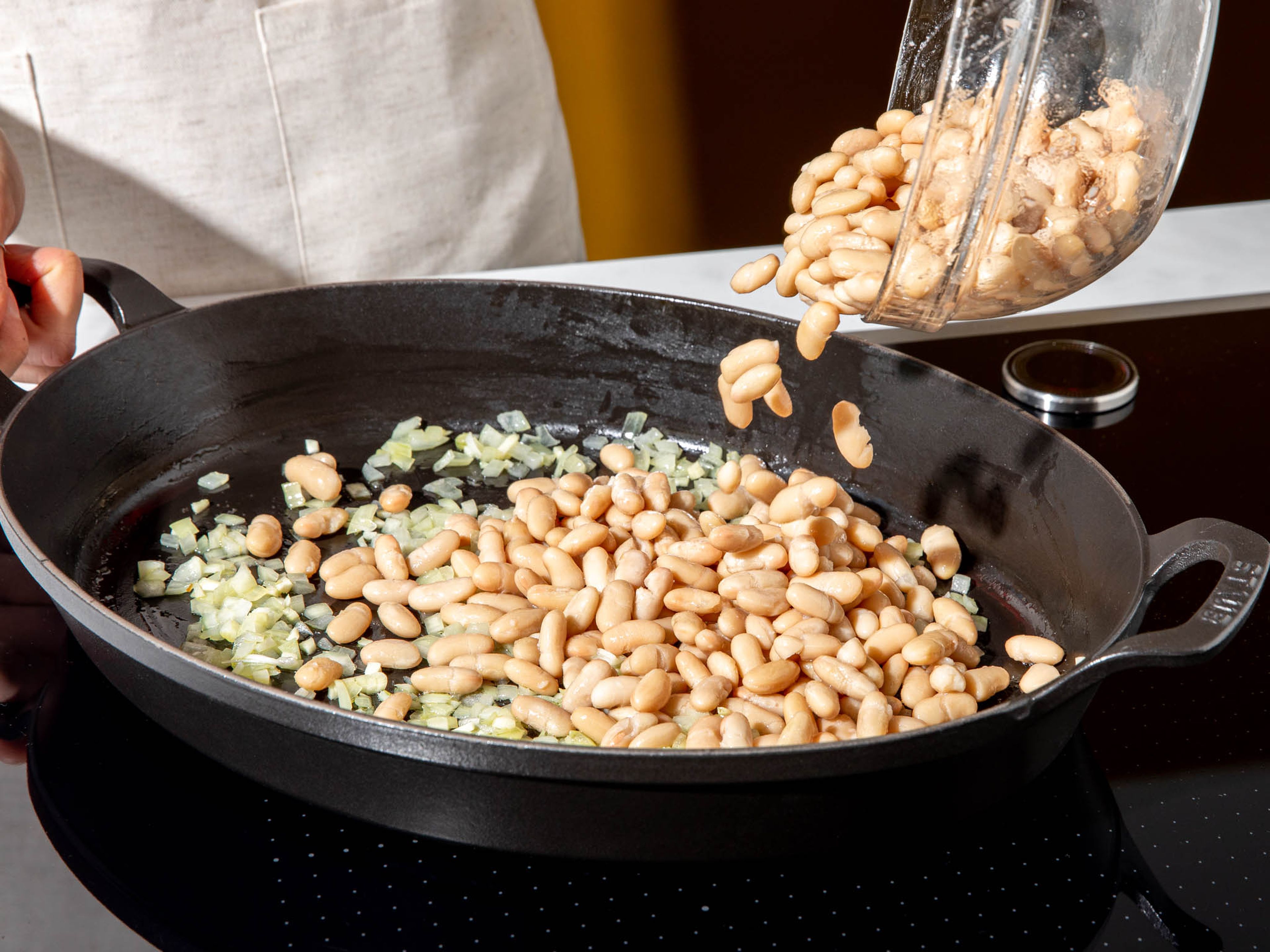 Add some olive oil to a frying pan or ovenproof dish. Then add garlic and onion and sauté until glossy. Add the beans and tomato paste, and cook briefly. Stir in the canned crushed tomatoes and Worcestershire sauce and bring everything to a boil. Season to taste with salt and pepper.