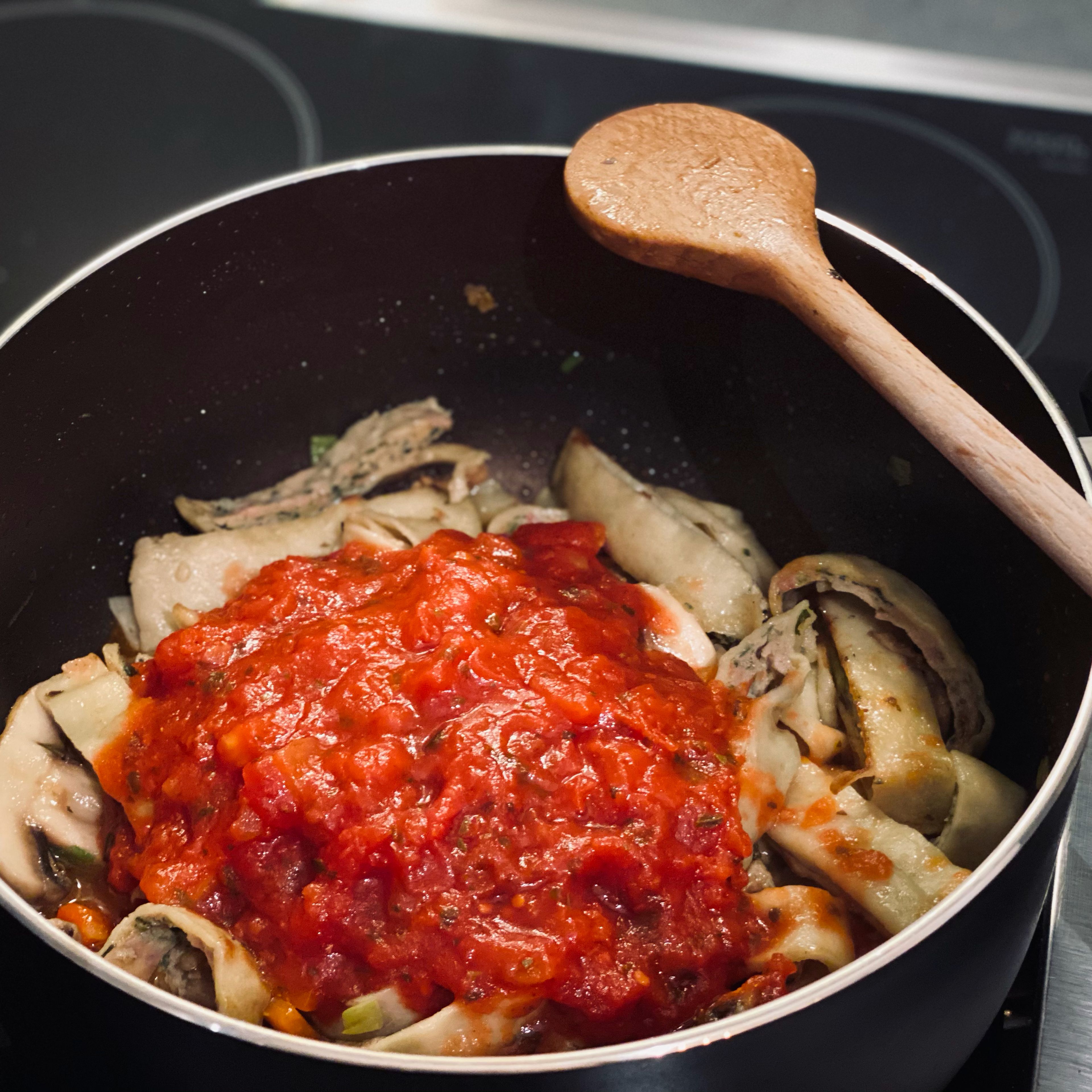 Stückige Tomaten zu dem Gemüse und den Maultaschen in den Topf geben, bei mittlerer Hitze ca. 7 Minuten köcheln lassen bis das Gemüse gar ist.