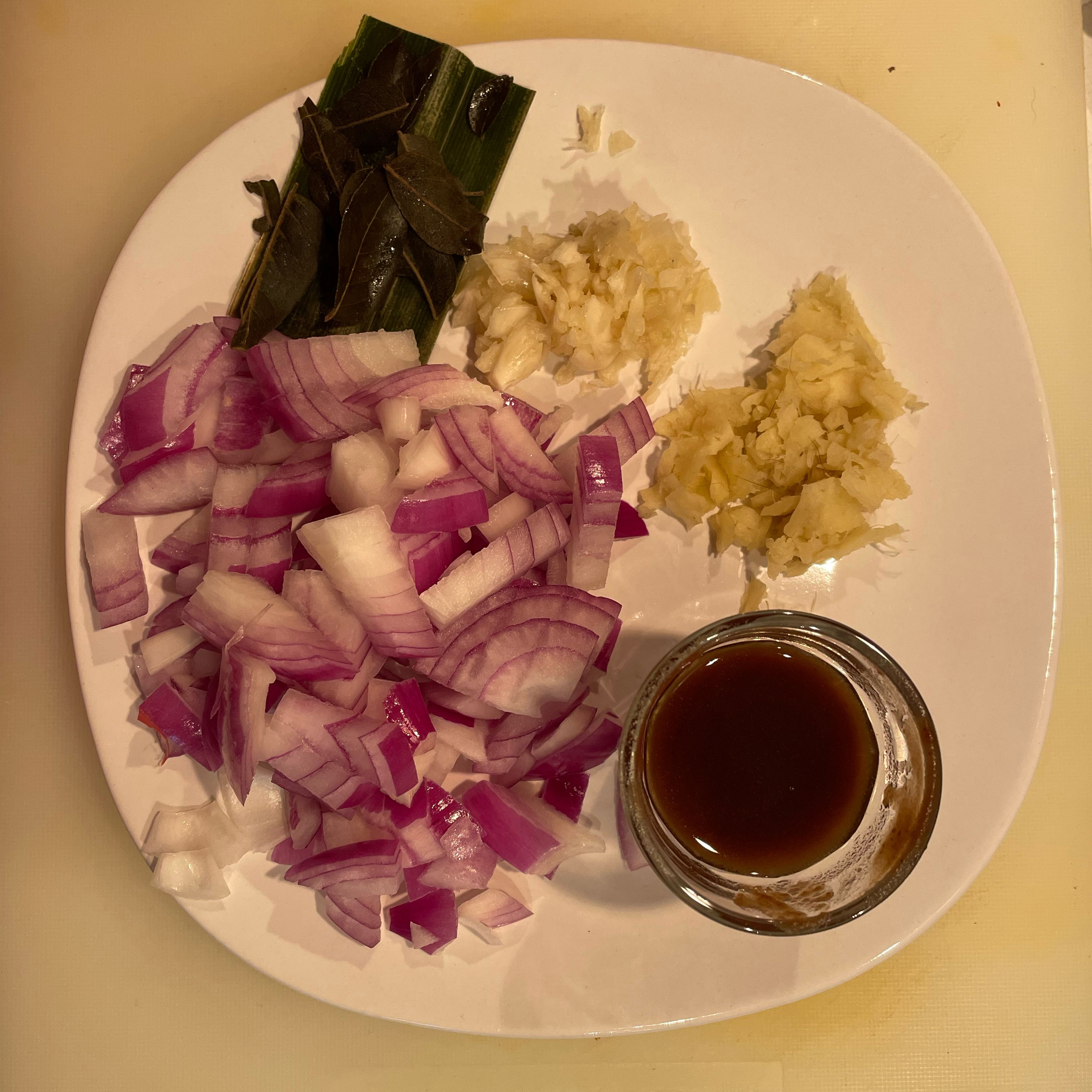 Dice onions, crush ginger and garlic, prepare tamarind juice, pandan leaf and a sprig of curry leaves. Cut beef against the grain.