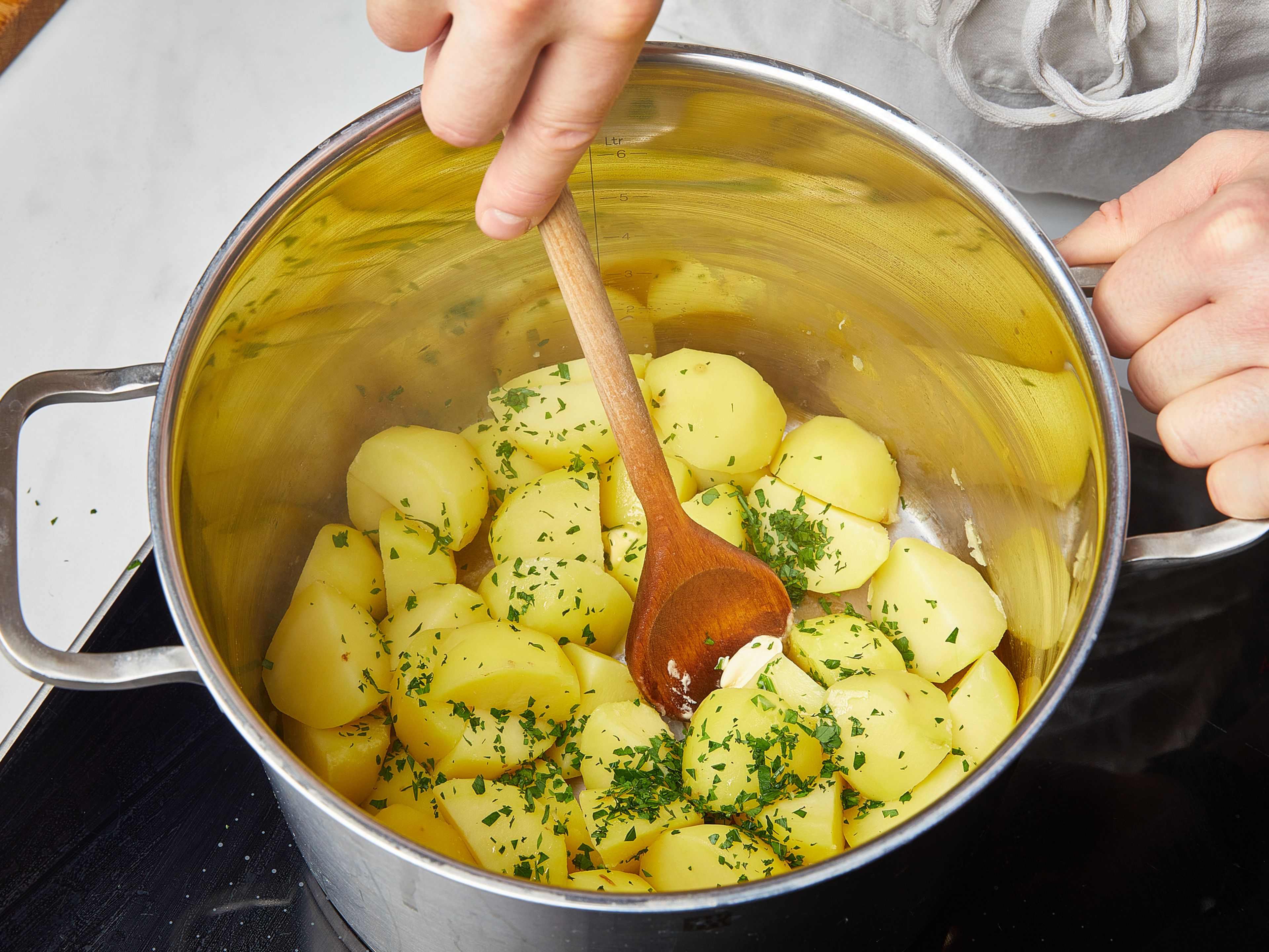 Den zuvor verwendeten großen Topf ausspülen und mit Wasser füllen. Salz hinzufügen und zum Kochen bringen. In der Zwischenzeit die Kartoffeln schälen, je nach Größe halbieren oder vierteln, in den Topf geben und bei mittlerer Hitze ca. 10–15 Min. kochen. Dann das Wasser abgießen, die Kartoffeln zurück in den Topf geben und mit Margarine ca. 2 Min. andünsten. Vom Herd nehmen und mit einem Deckel abdecken. Kurz vor dem Servieren die restliche Petersilie unterheben. Die Kohlrouladen mit Petersilienkartoffeln und Zwiebelsoße servieren.