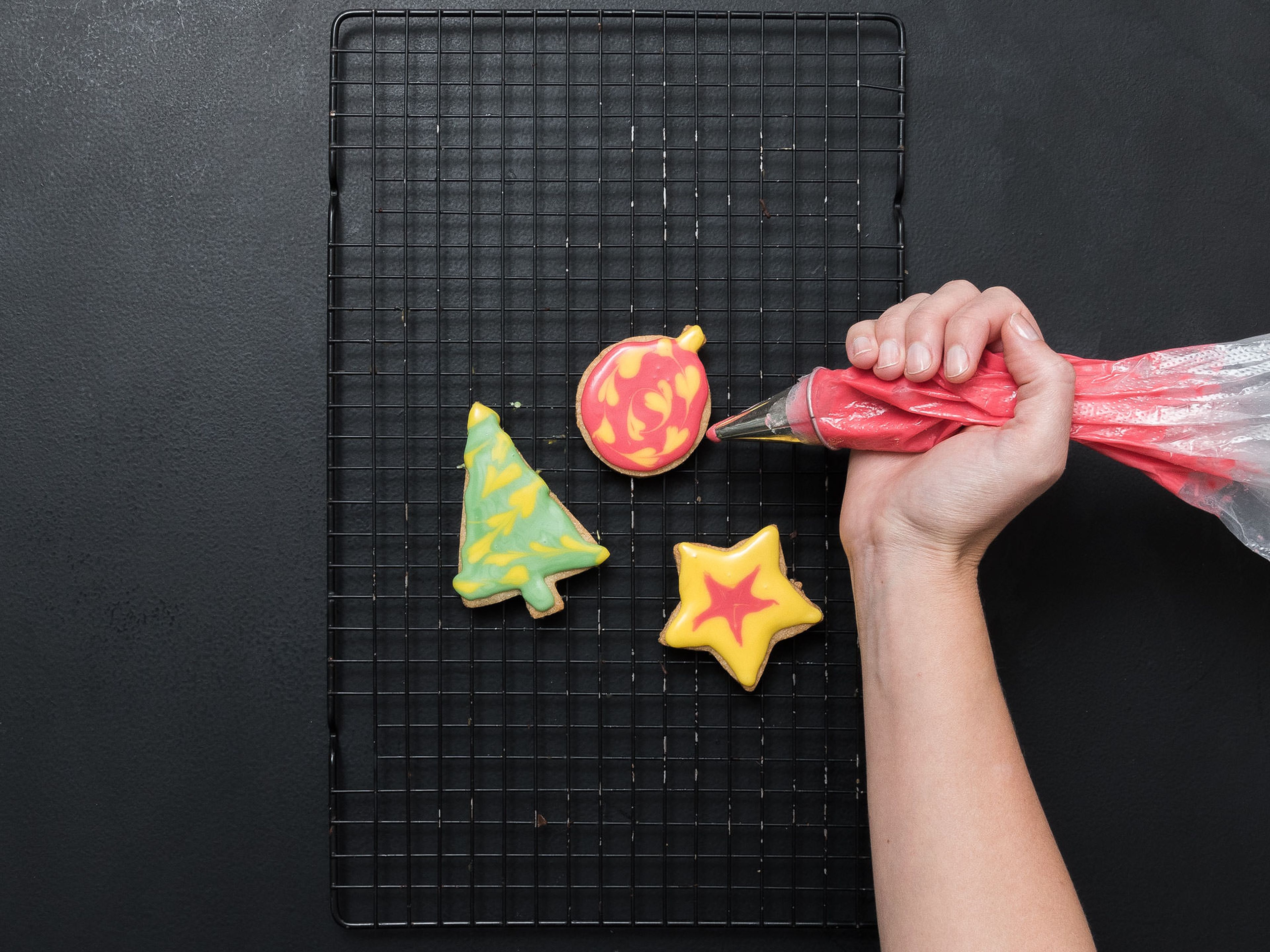 Decorate the cookies with the colorful icing. For a pattern on the icing, apply dots or lines on top of the base layer of icing. Before the icing dries, use a toothpick to pull the top color through the bottom layer in a pattern you like. Allow to dry over night before packaging. Enjoy!