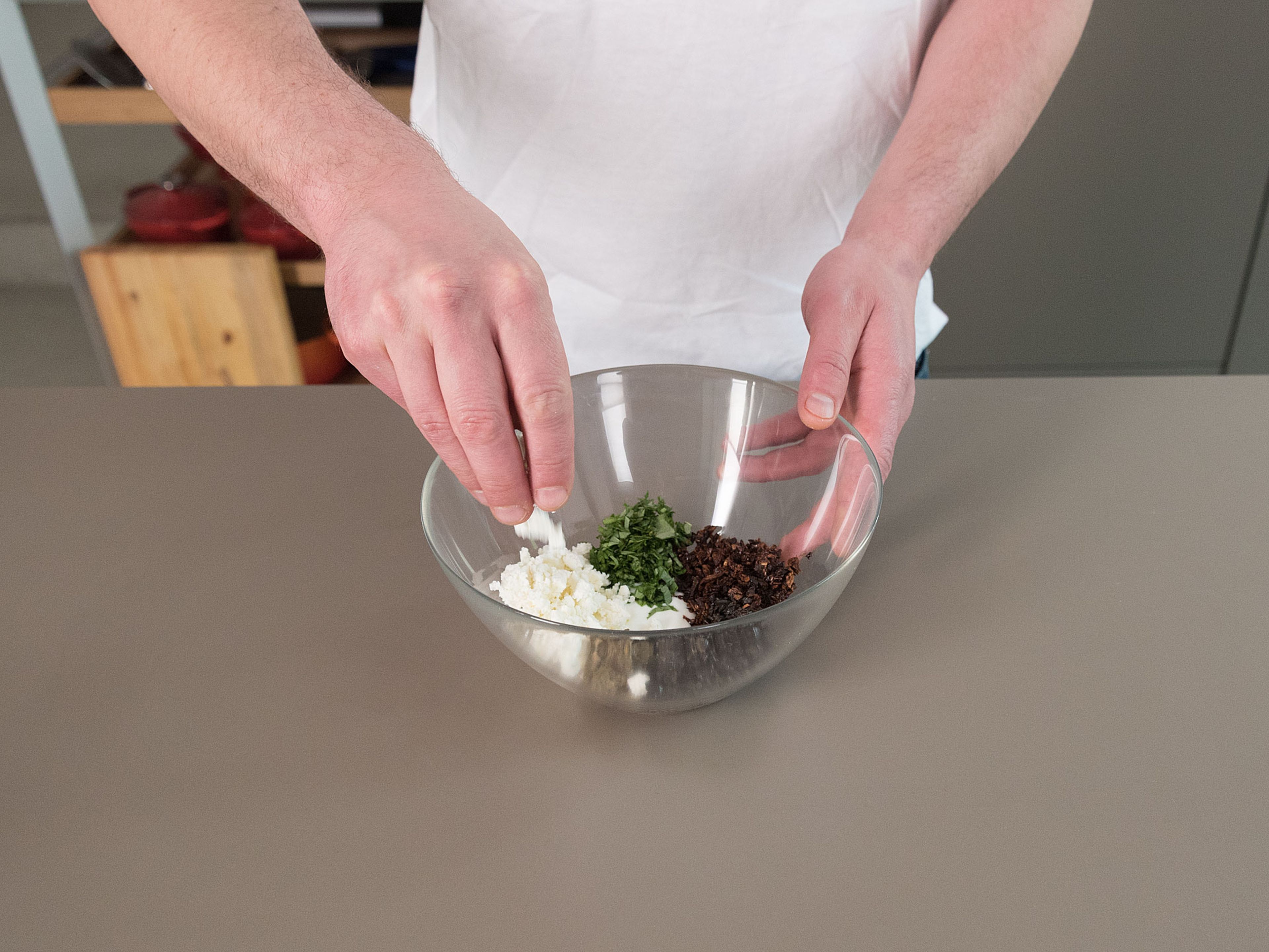 Feta mit Joghurt in einer Schüssel vermengen, Oliven, getrocknete Tomaten, gehackten Basilikum und Olivenöl dazugeben. Miteinander verrühren und mit Salz und Pfeffer abschmecken.