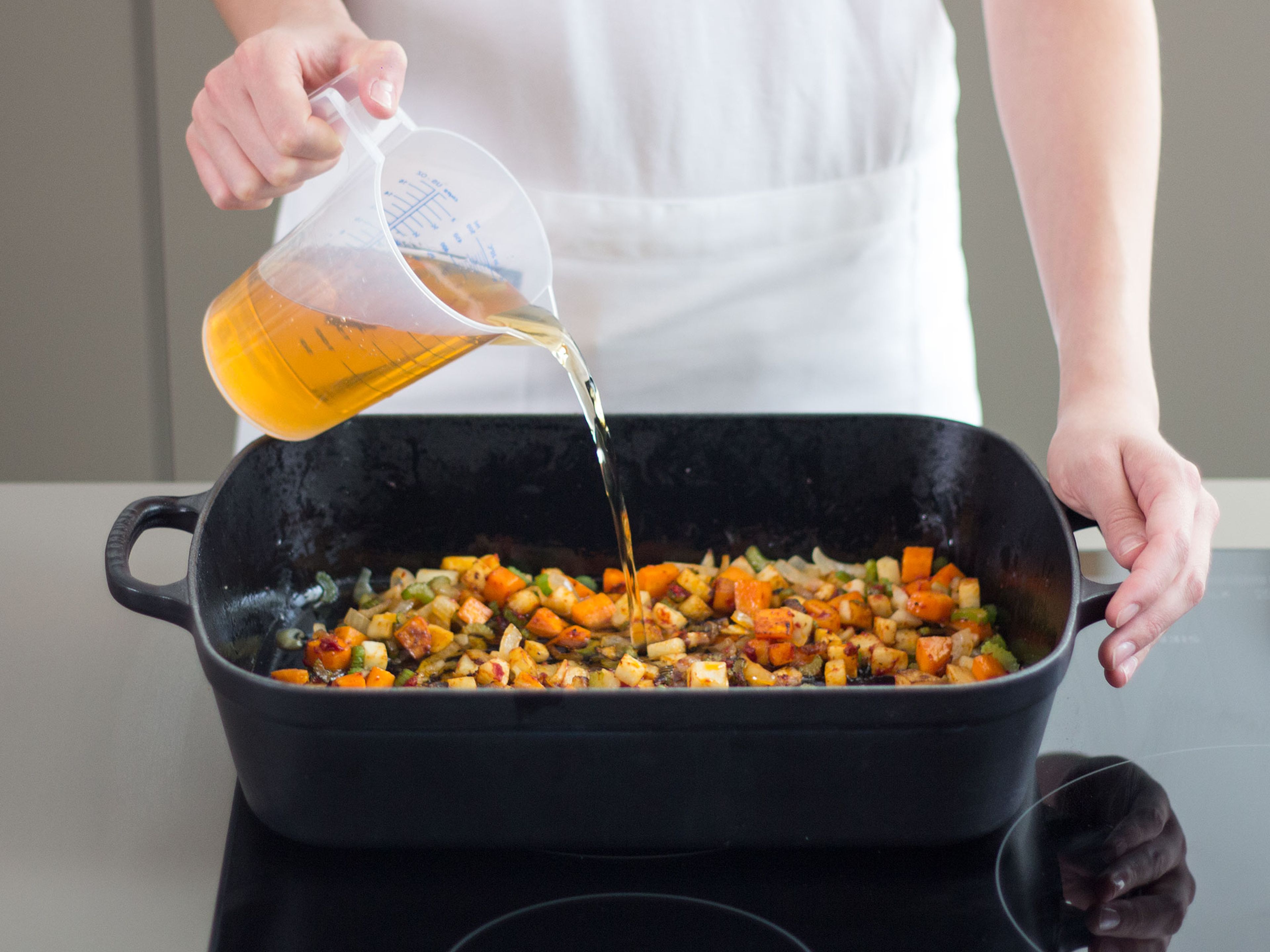 Karotte, Knollensellerie, Zwiebel und Tomatenmark in einem Bräter mit etwas Pflanzenöl bei mittlerer Hitze ca. 8 – 10 Min. braten, bis sie etwas weich geworden sind. Mit restlichem Apfelsaft ablöschen und Schweinebraten mit der Schwarte nach oben auf das Gemüse legen. Im vorgeheizten Backofen bei 150°C ca. 3 h garen. Auf dem Sauerkraut und gerösteten Gemüse anrichten und genießen!