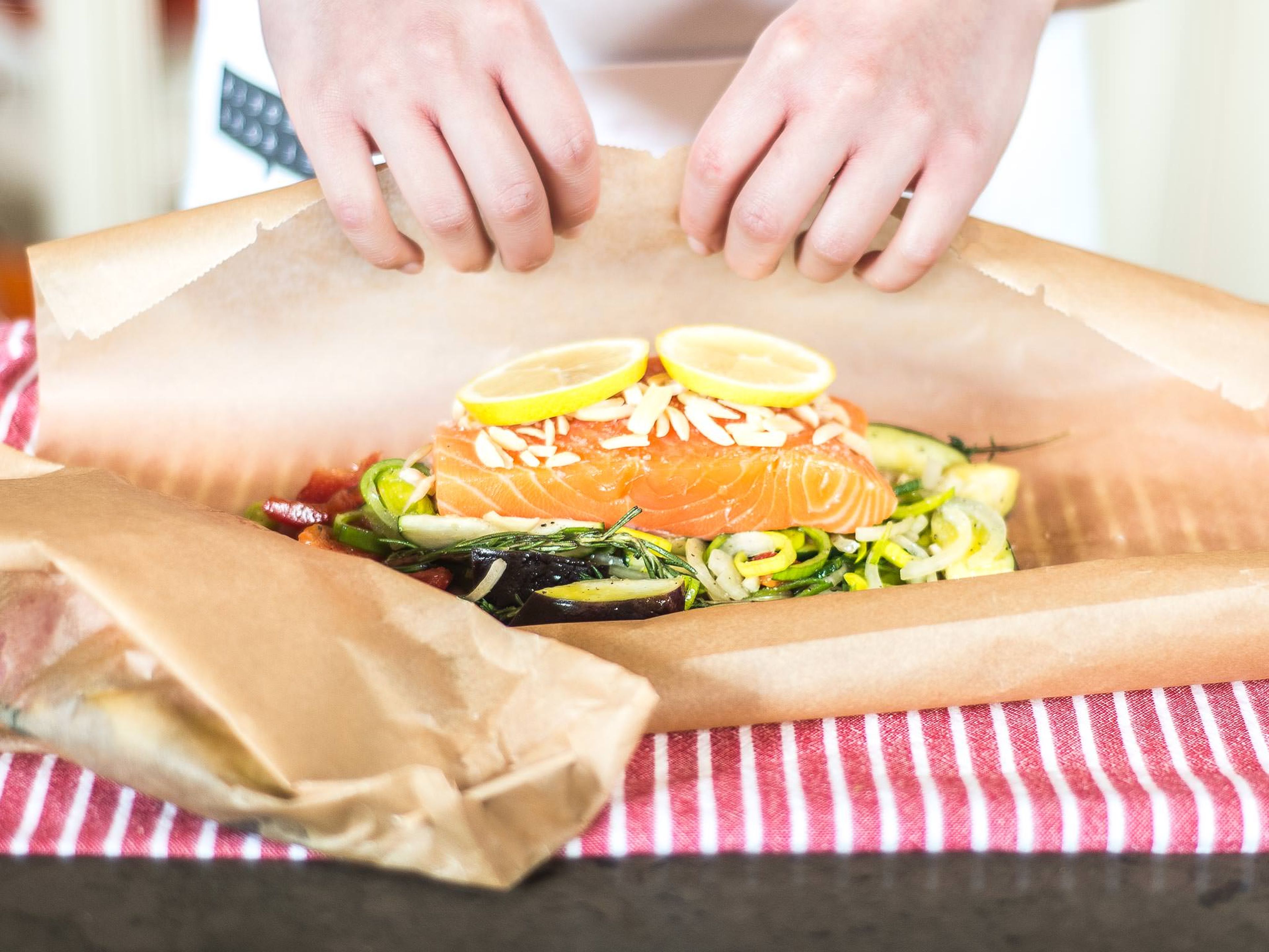 Das Gemüse auf zwei Backpapierbögen verteilen. Lachs in Portionen schneiden und auf das Gemüse legen. Mit Salz und Mandelblättchen bestreuen. Zitronenscheiben darauflegen. Backpapier verschließen und bei 140 °C für ca. 15–20 Min. in der Heißluftfritteuse garen. Backpapier oben aufschneiden, leicht öffnen und direkt servieren.