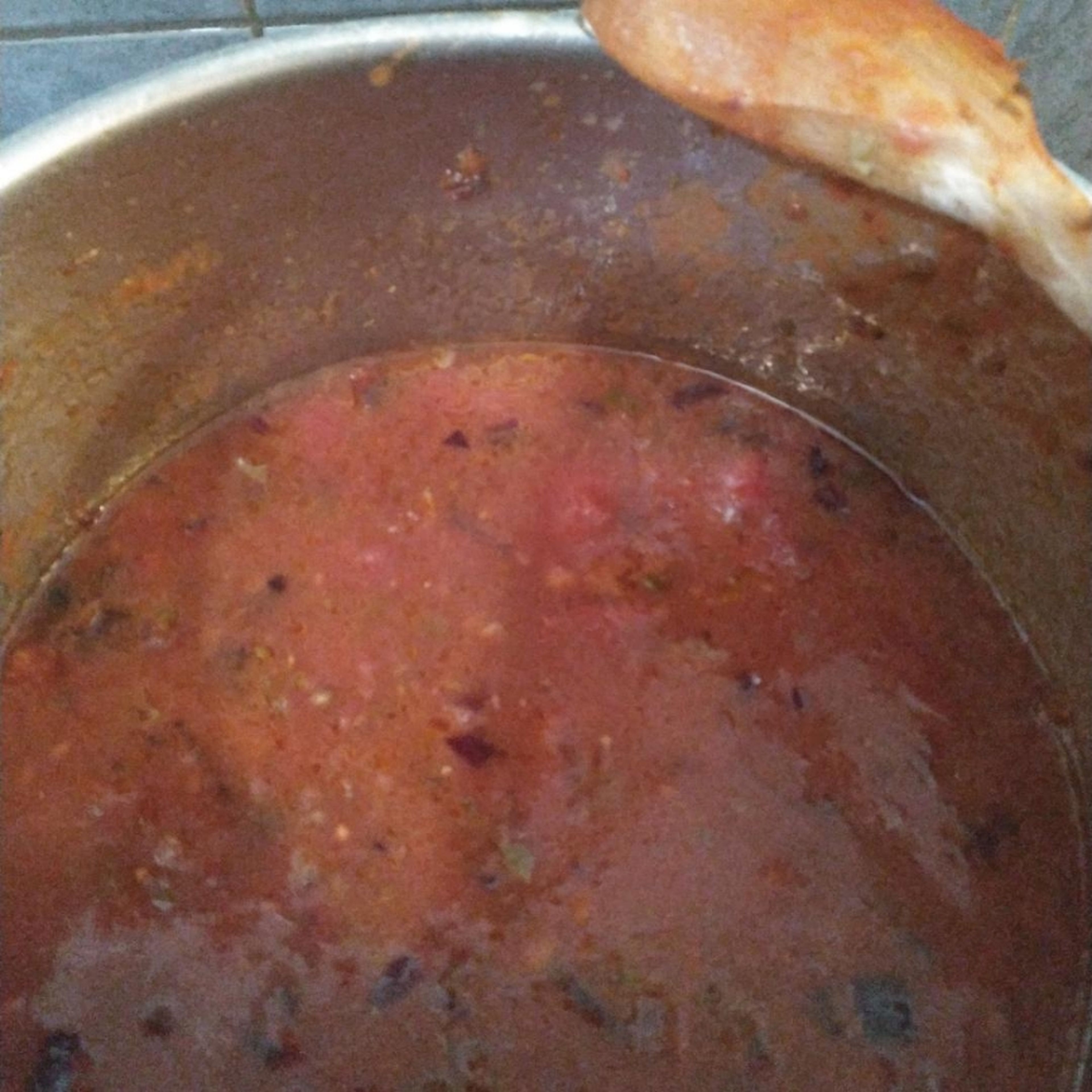 Add the tinned tomatoes. Fill up the can with water, swirl around and add to the pan. Add a pinch of sugar - brown sugar will give it a rich flavour, but this isn't an ingredient you need to fuss over. Simmer over a low heat for 15 minutes, stirring occasionally.