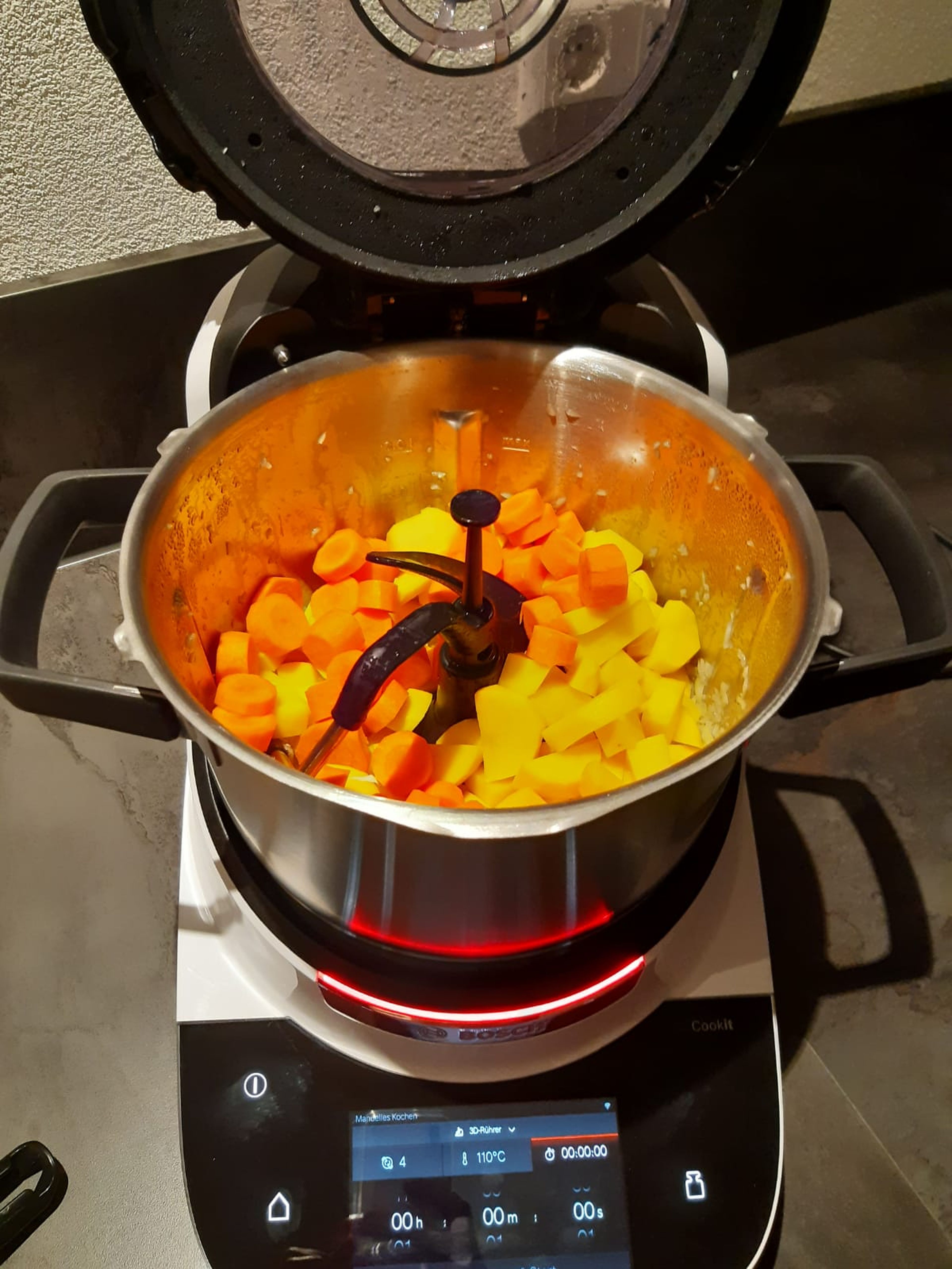 Die geschnittenen Karotten und Kartoffeln hinzufügen und weitere 3 Minuten bei geschlossenem Deckel ohne eigesetzten Messbecher mitdünsten (3D-Rührer|Stufe 4|110 °C|3 Min.).