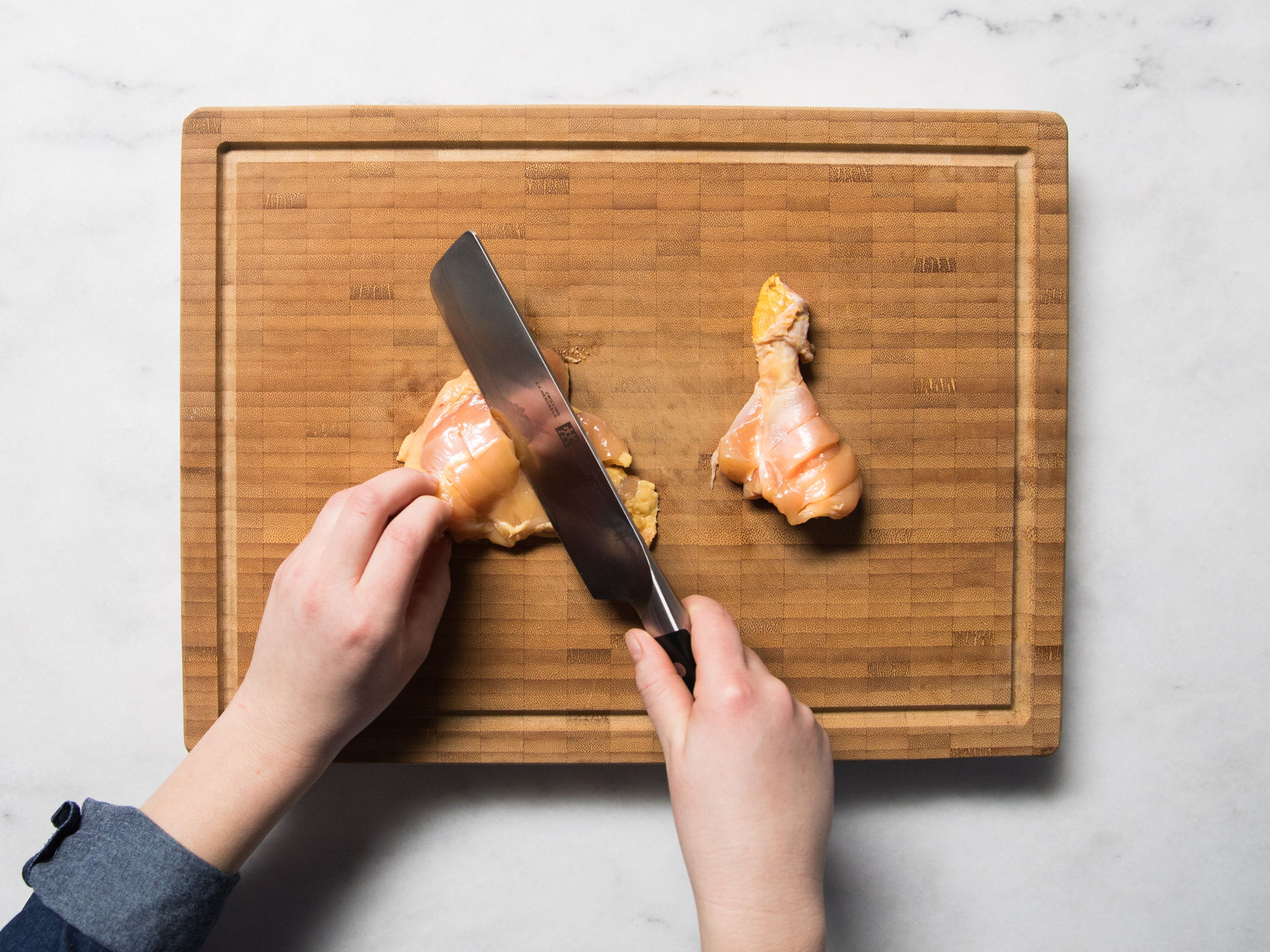 Separate the chicken thighs and drumsticks by cutting through the joint. Score the chicken a few times on one side, set aside. Peel and mince garlic and ginger. Add salt and use the flat side of a knife to work the mixture into a paste.