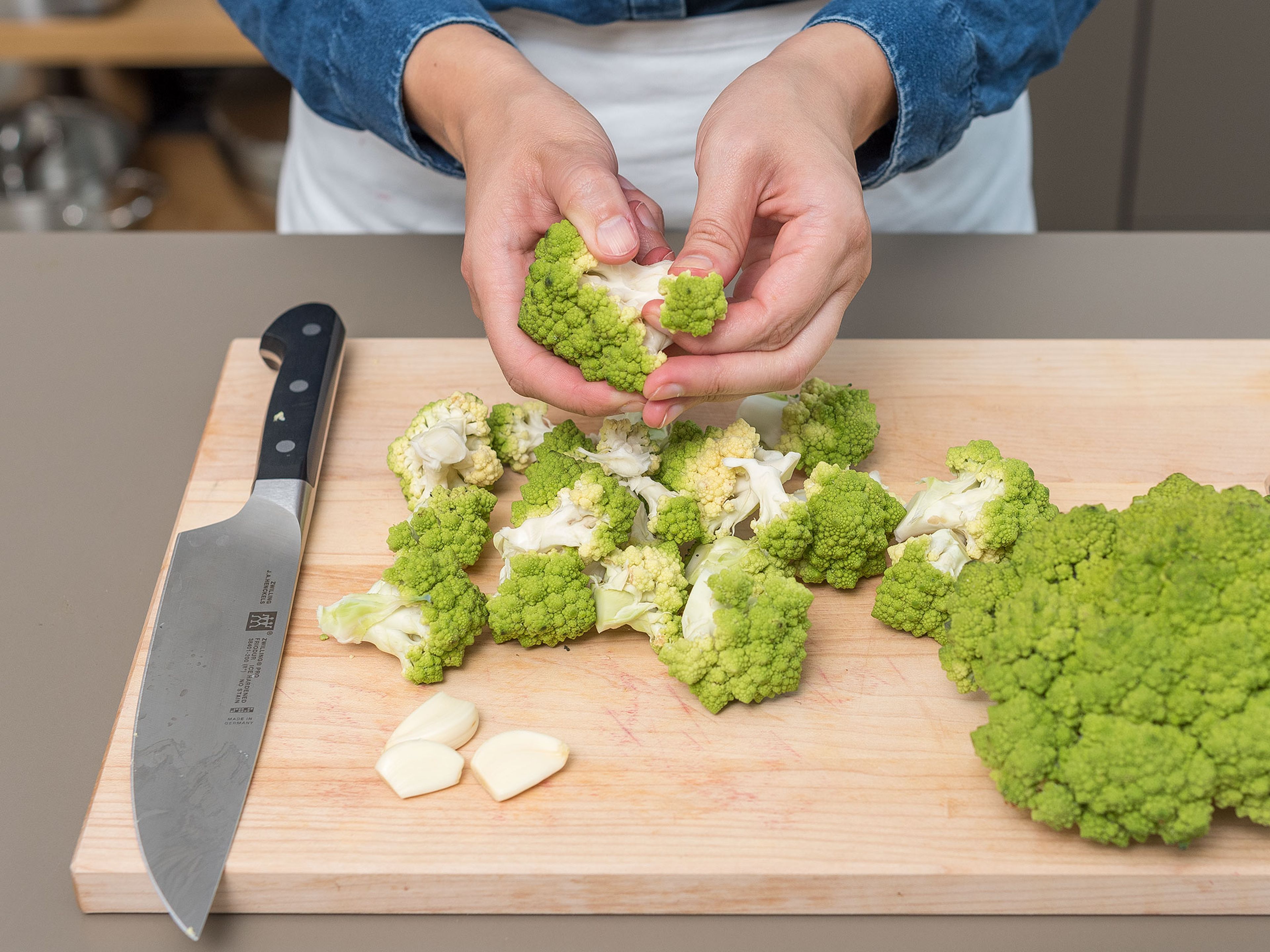 Preheat the oven to 180°C/350°F on convection heat. Thoroughly rinse the Romanesco under cold water, dry, remove the outer leaves, and cut the florets from the stalk. Peel the garlic cloves and mince.